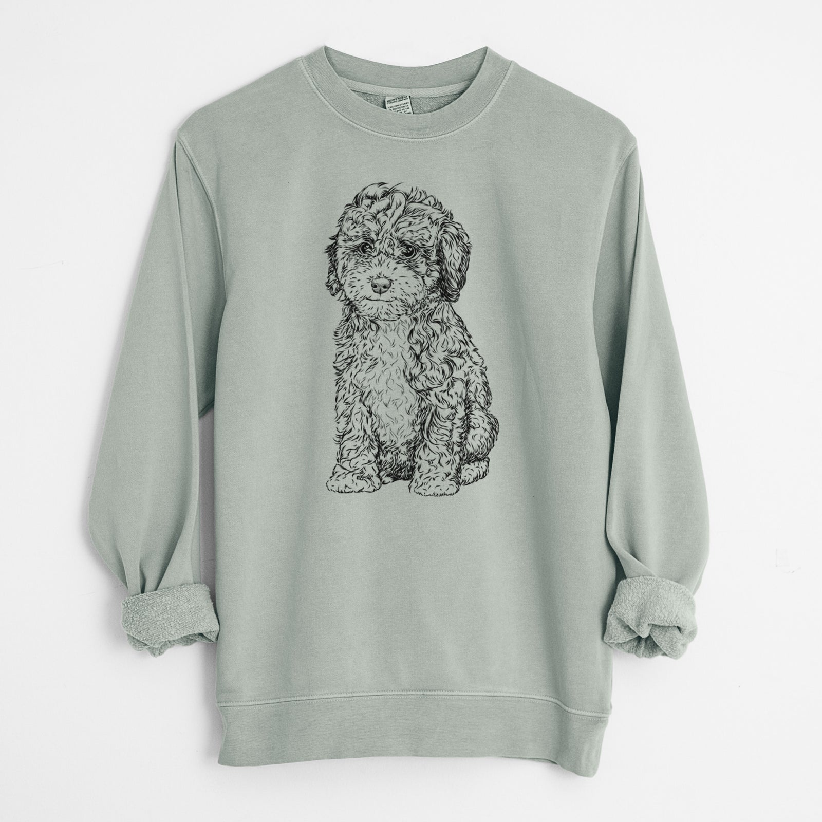 Hand-drawn sketch of Sweet Tea the Mini Doodle on a Sage Unisex pigment dyed crew sweatshirt