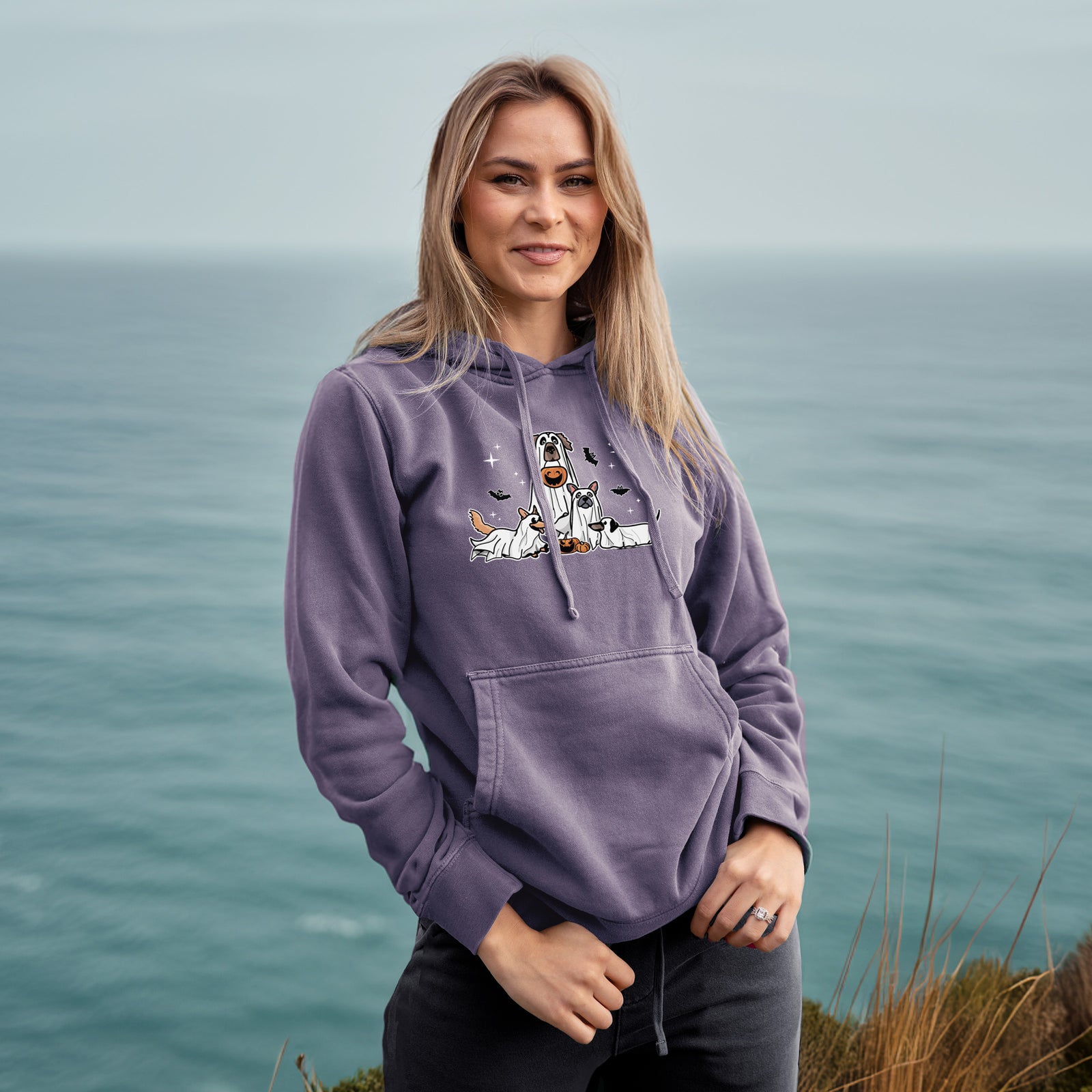 'Vibrant Ghost Pups' design on a Plum Unisex pigment dyed hoodie, worn by a woman