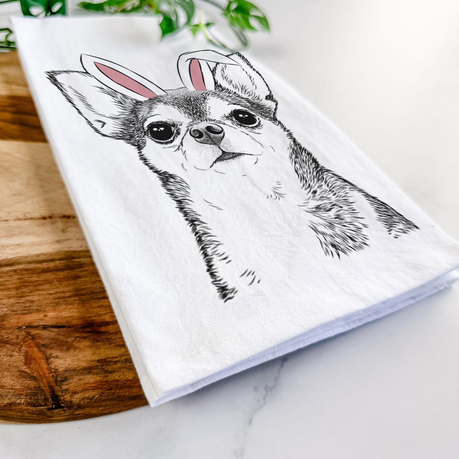 Hand-drawn sketch of Baby the Chihuahua wearing Easter bunny ears on a tea towel