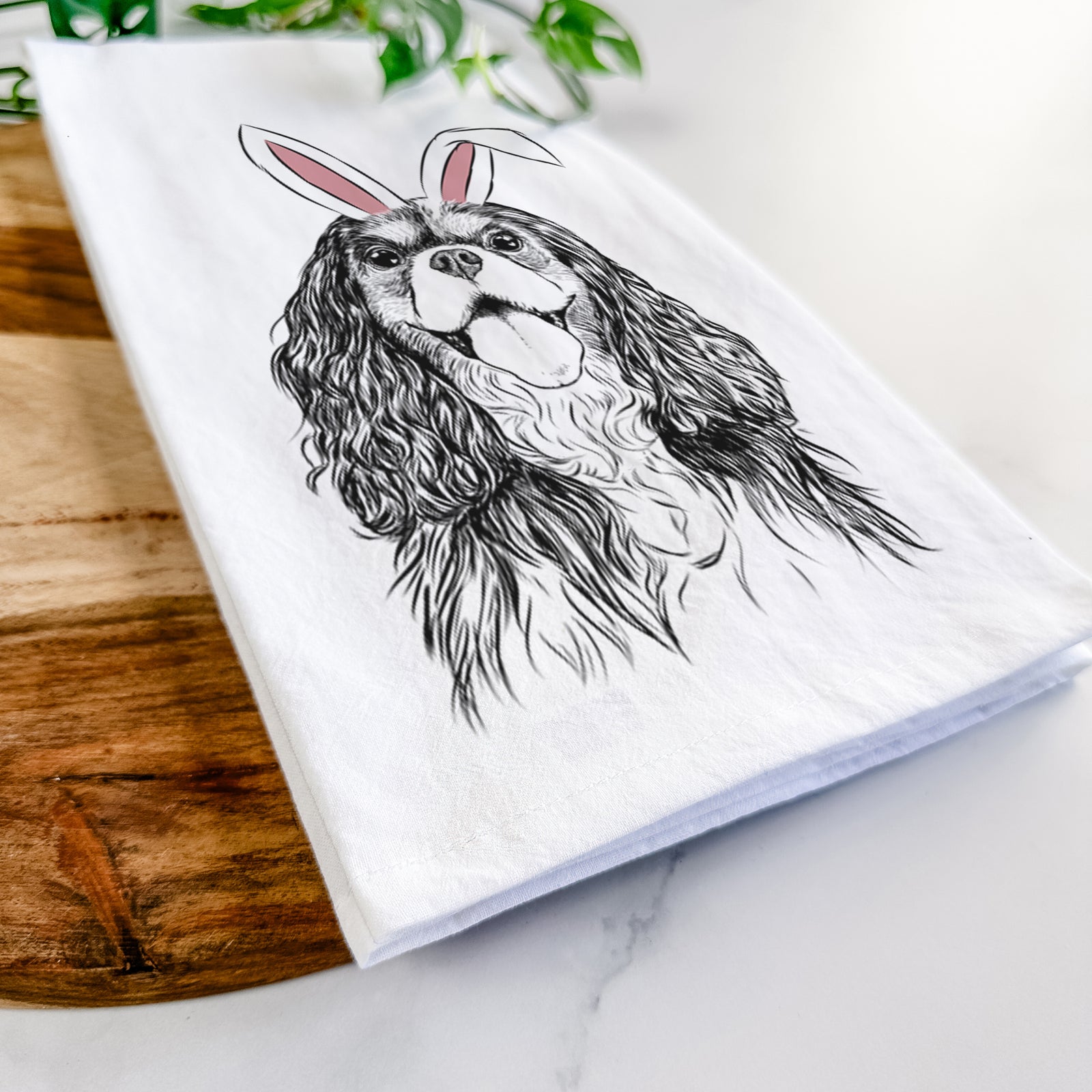 Hand-drawn sketch of Brandy the Cavalier King Charles Spaniel wearing Easter bunny ears on a tea towel
