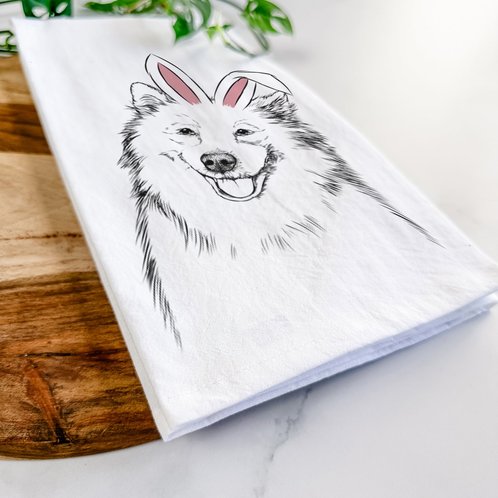 Hand-drawn sketch of Caico the Samoyed wearing Easter bunny ears on a tea towel