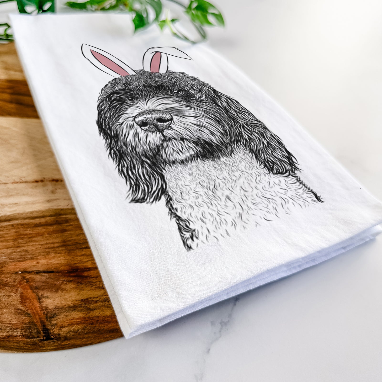 Hand-drawn sketch of Chris the Portuguese Water Dog wearing Easter bunny ears on a tea towel