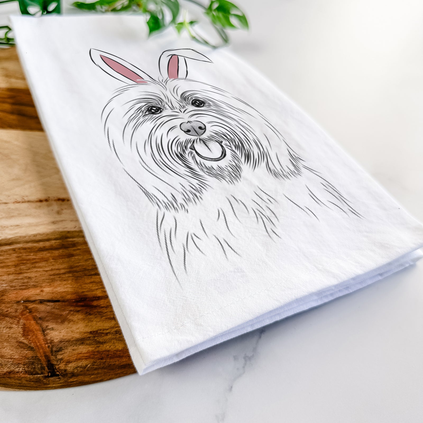 Hand-drawn sketch of Claude the Coton de Tulear wearing Easter bunny ears on a tea towel