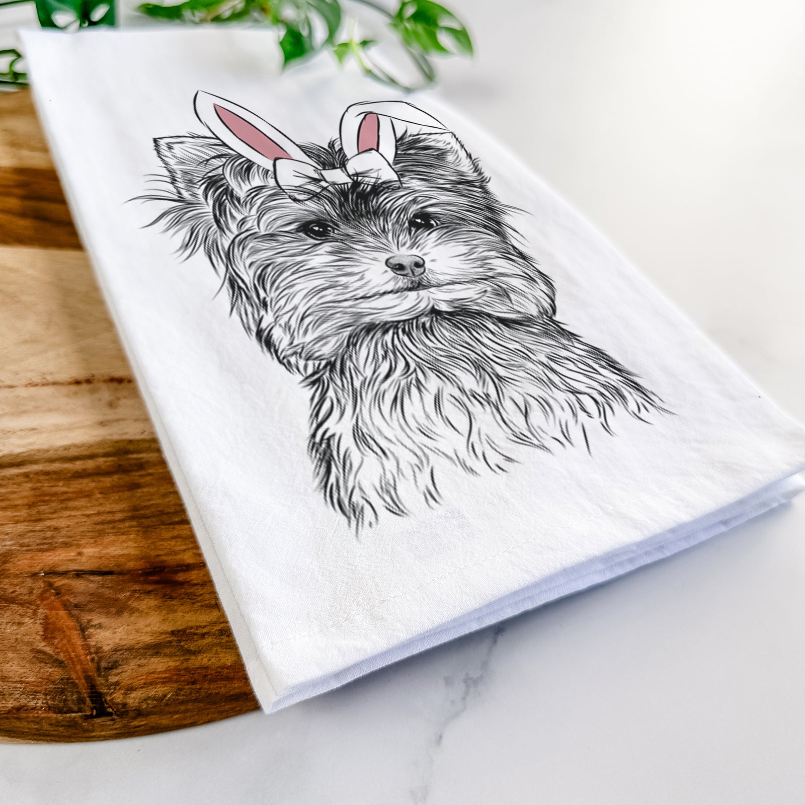 Hand-drawn sketch of Cricket the Biewer Terrier wearing Easter bunny ears on a tea towel