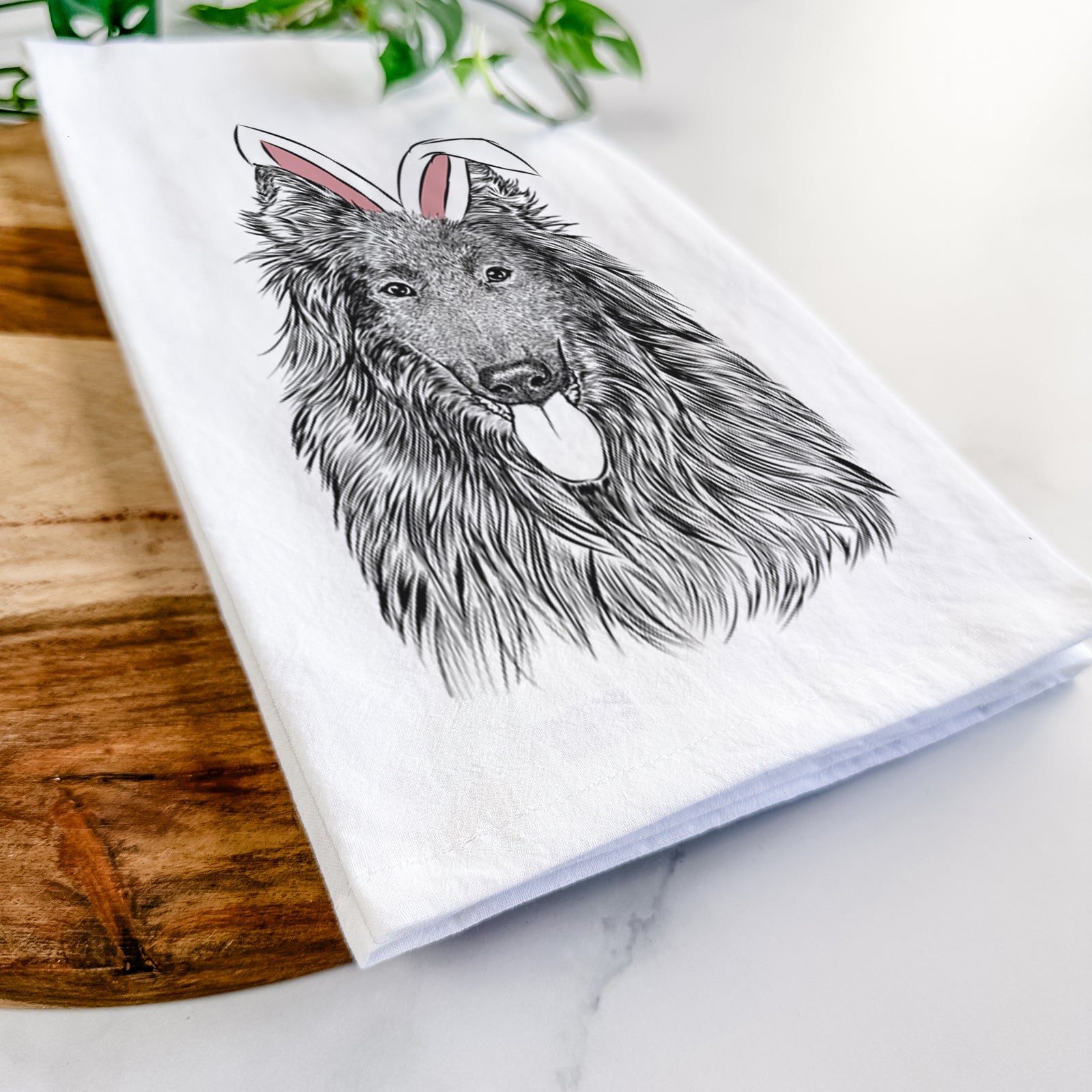 Hand-drawn sketch of Daan the Belgian Shepherd wearing Easter bunny ears on a tea towel