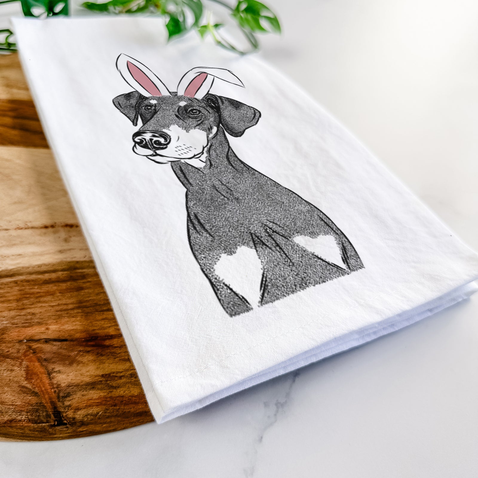 Hand-drawn sketch of Iroh the Doberman Pinscher wearing Easter bunny ears on a tea towel
