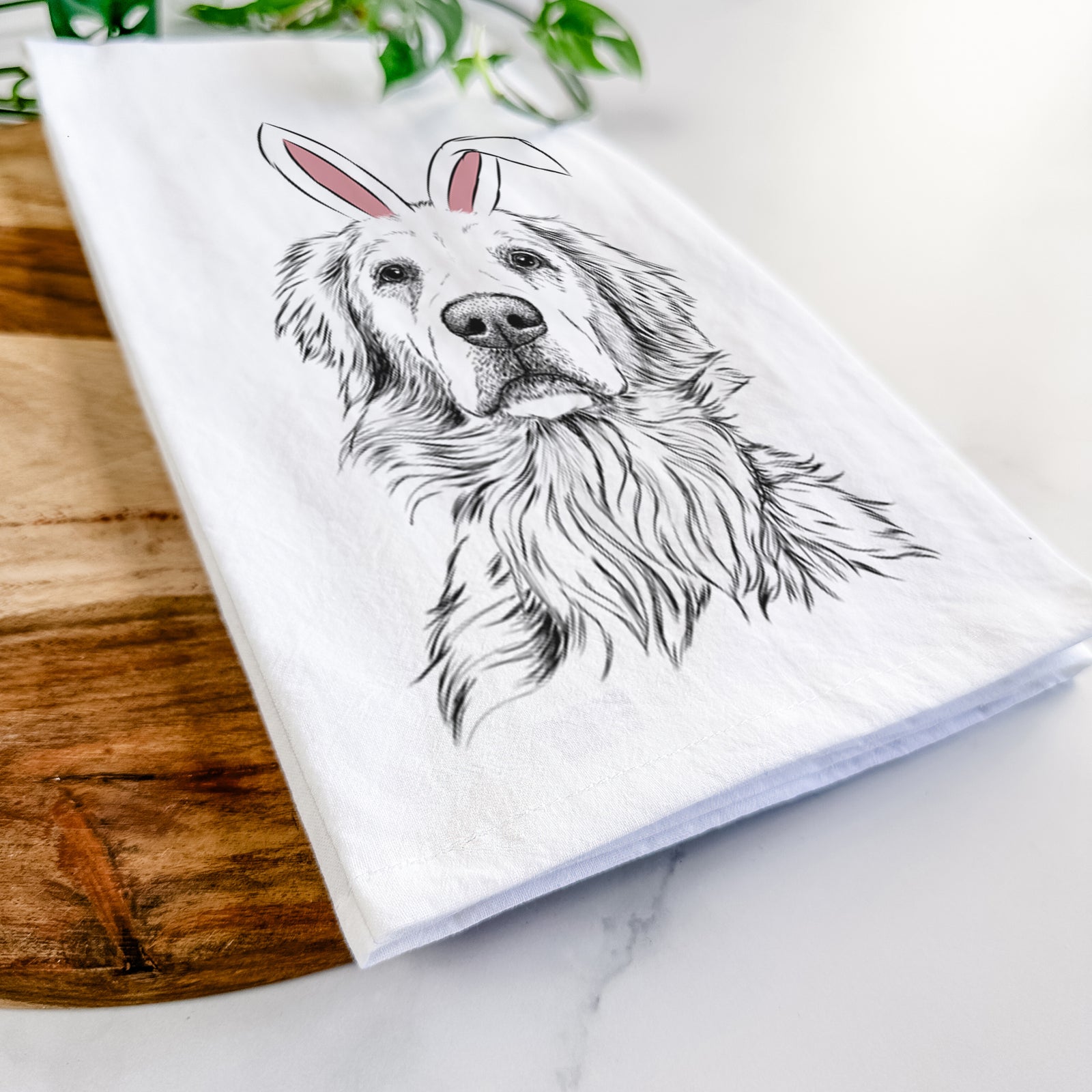 Hand-drawn sketch of Jake aroni the Golden Retriever wearing Easter bunny ears on a tea towel