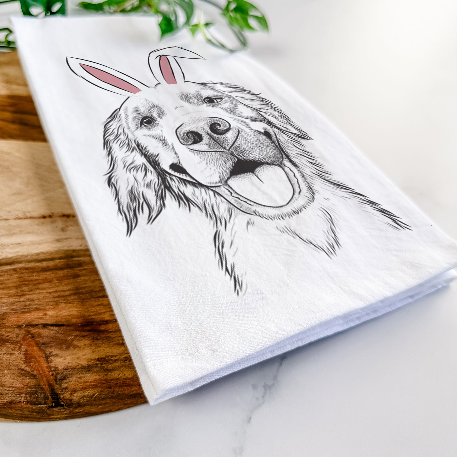 Hand-drawn sketch of Jordy the Golden Retriever wearing Easter bunny ears on a tea towel