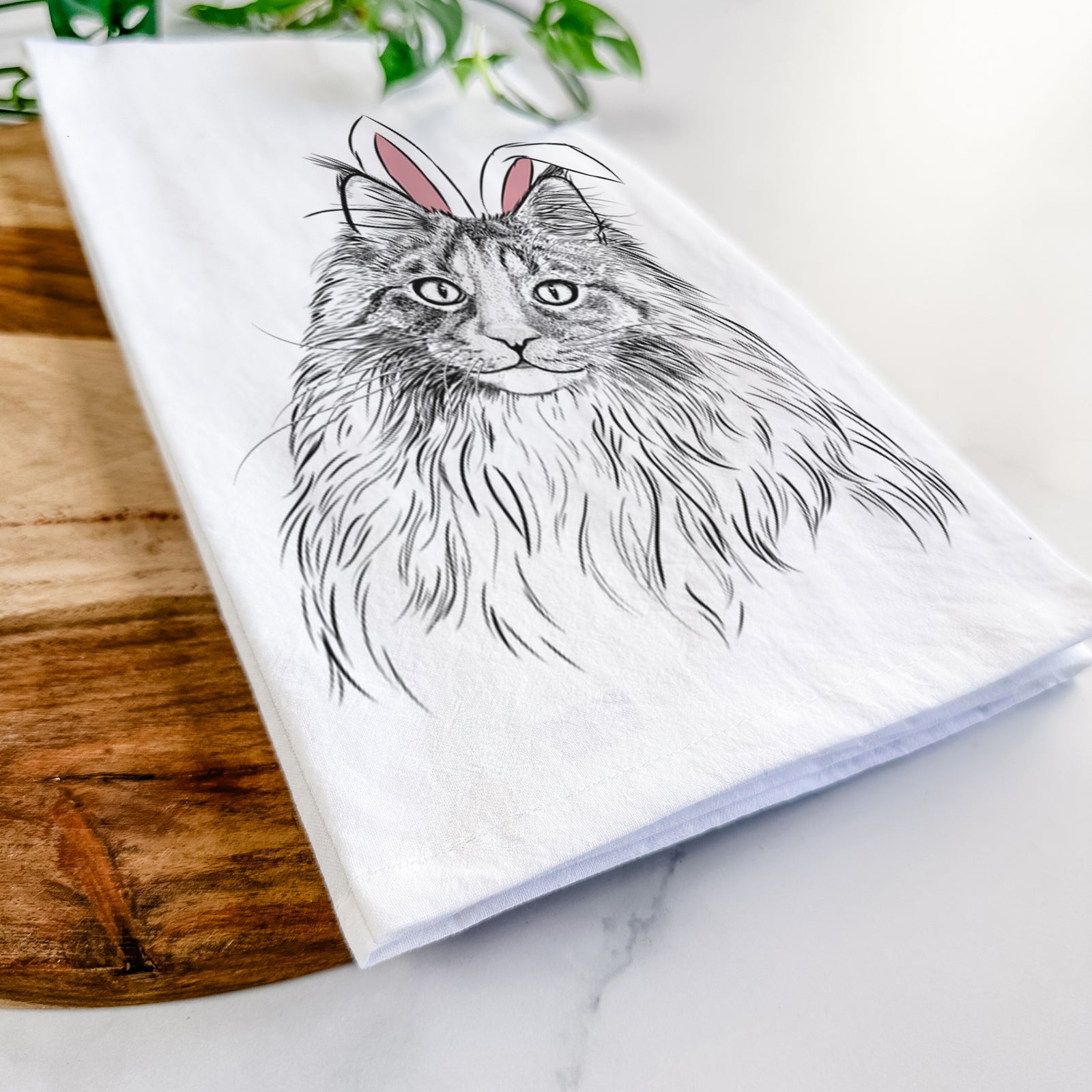 Hand-drawn sketch of Kiki the Maine Coon Cat wearing Easter bunny ears on a tea towel
