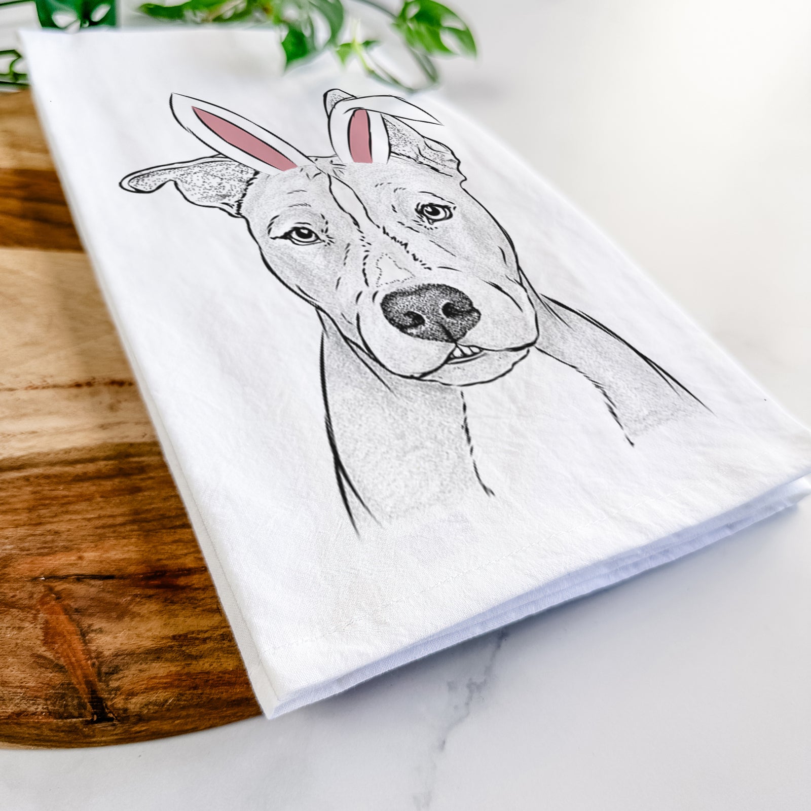 Hand-drawn sketch of Kisses the Pitbull wearing Easter bunny ears on a tea towel