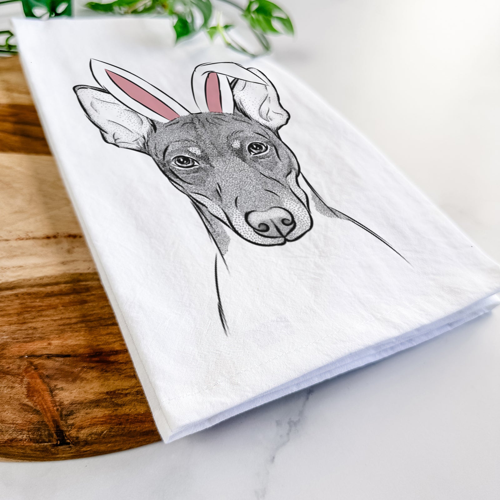Hand-drawn sketch of Knox the Rat Terrier wearing Easter bunny ears on a tea towel