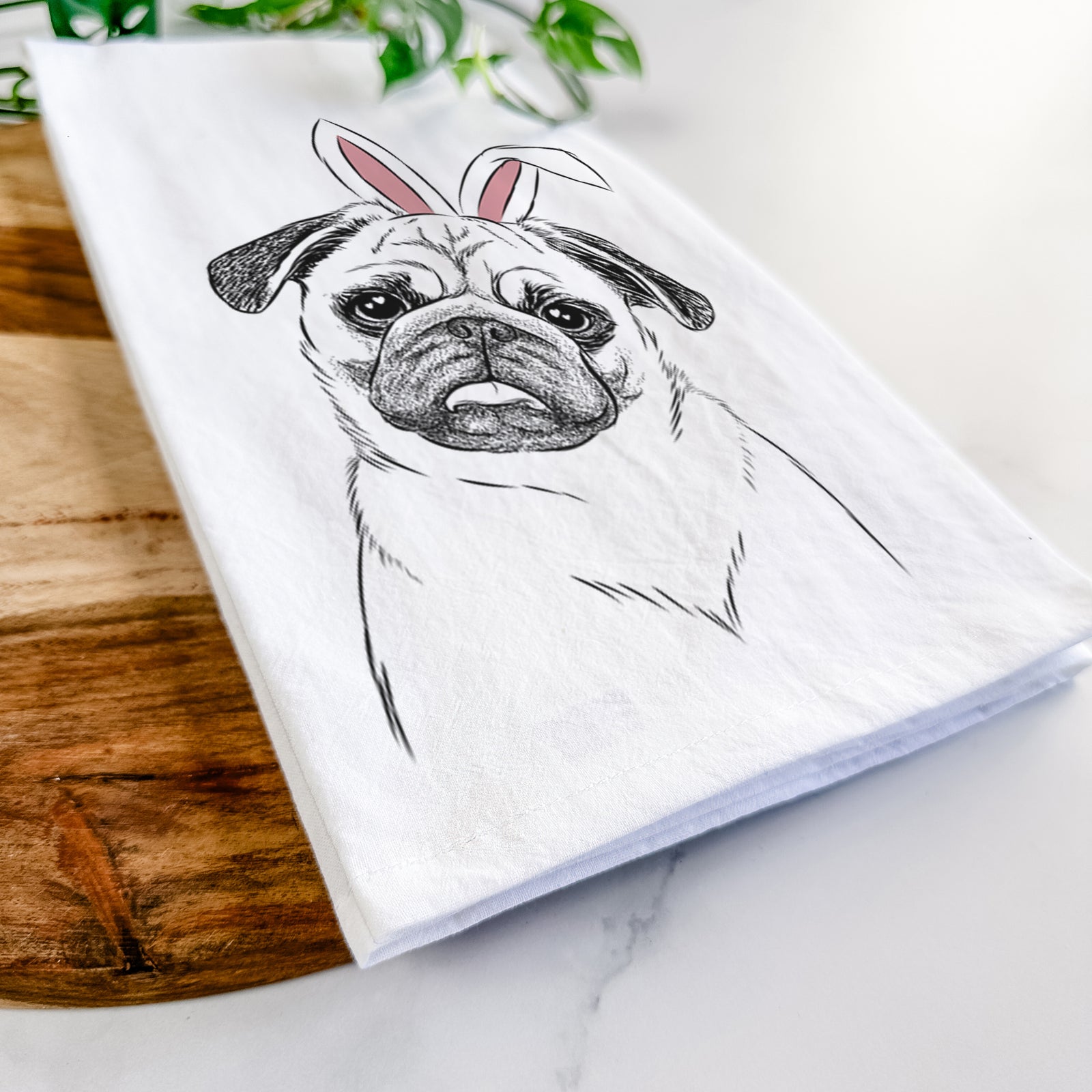 Hand-drawn sketch of Macy the Pug wearing Easter bunny ears on a tea towel