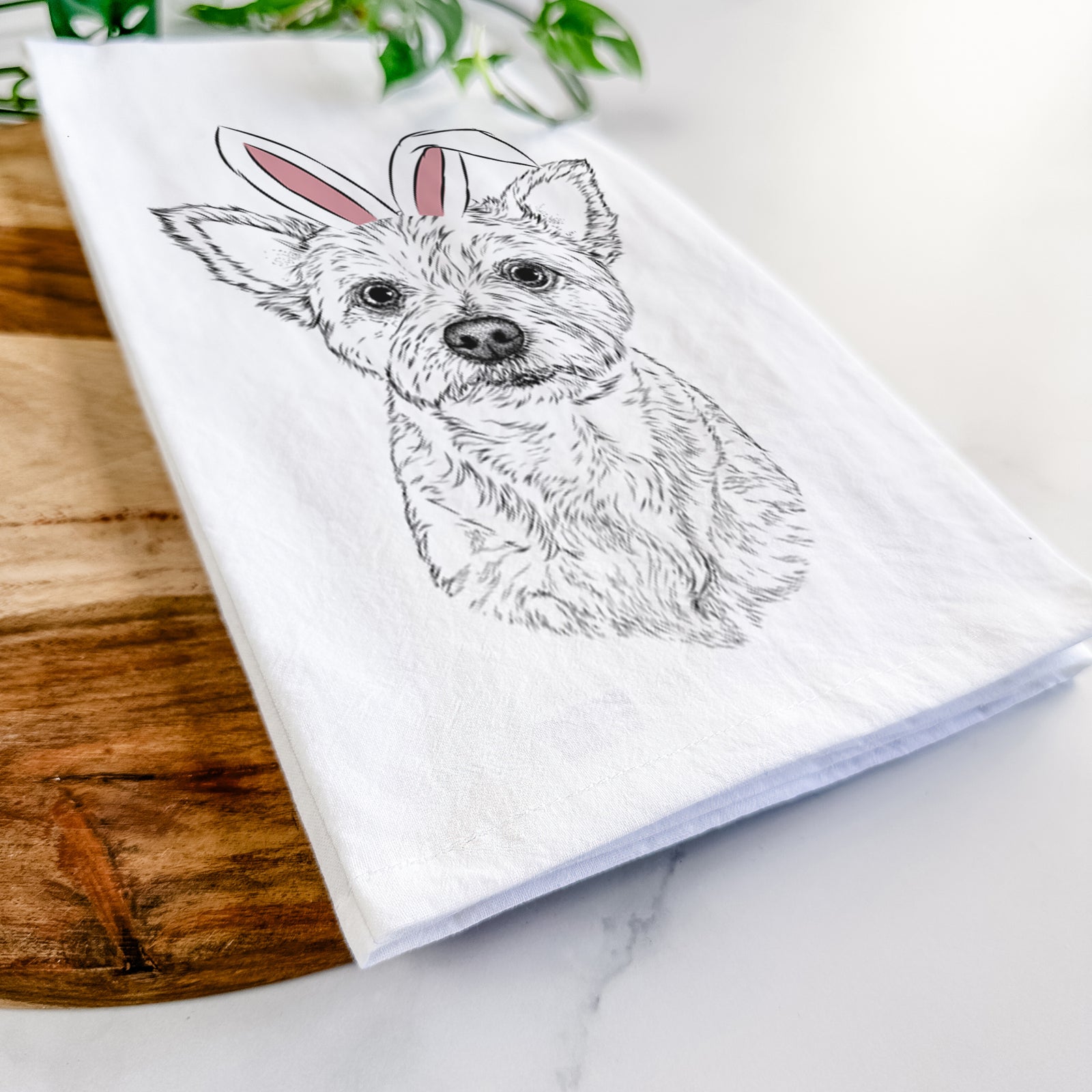 Hand-drawn sketch of Mango the Yorker Cairn Terrier Mix wearing Easter bunny ears on a tea towel