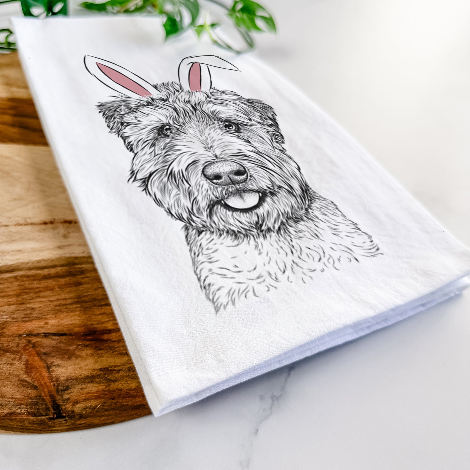Hand-drawn sketch of Milton the Soft Coated Wheaten Terrier wearing Easter bunny ears on a tea towel