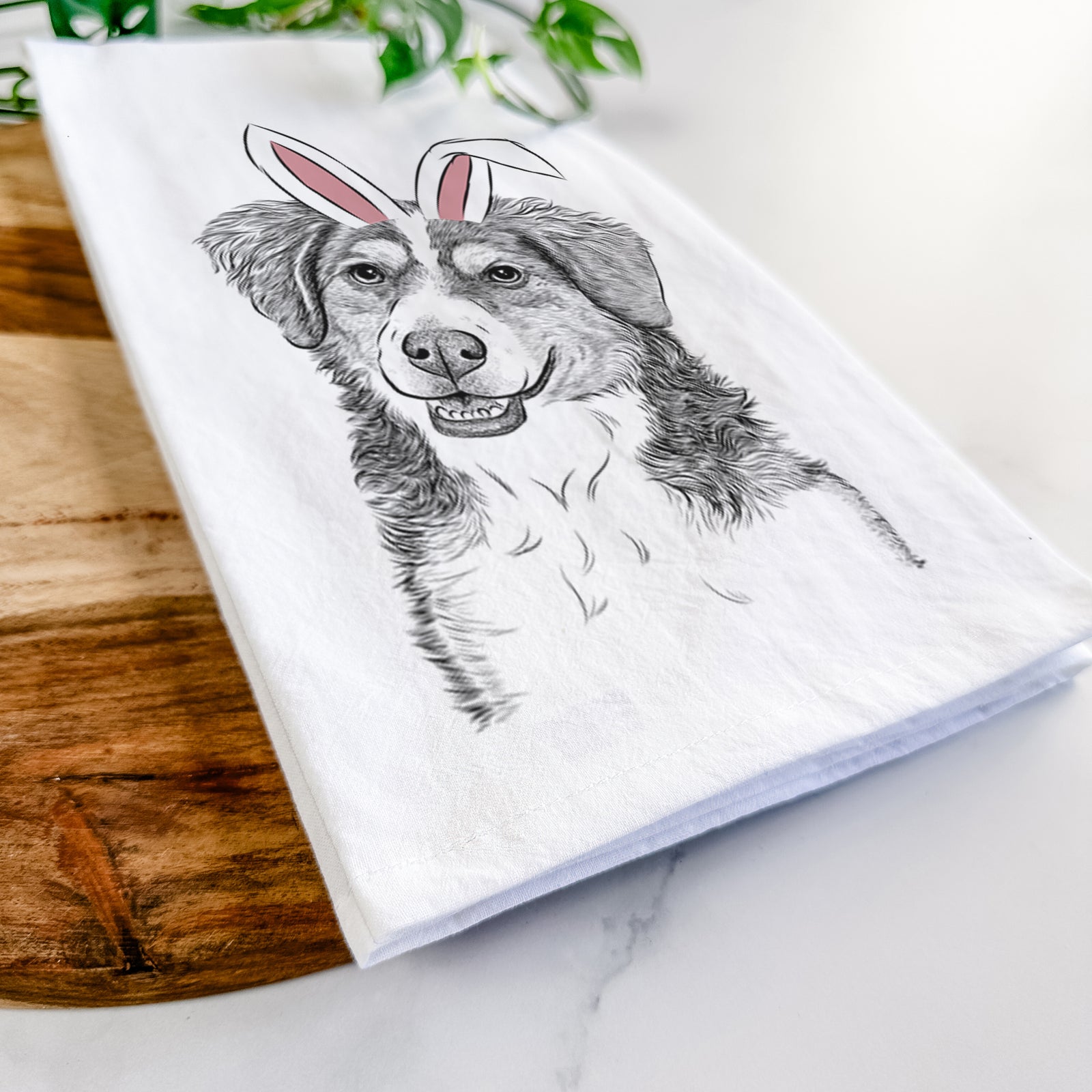 Hand-drawn sketch of Molly the Miniature Bernedoodle wearing Easter bunny ears on a tea towel