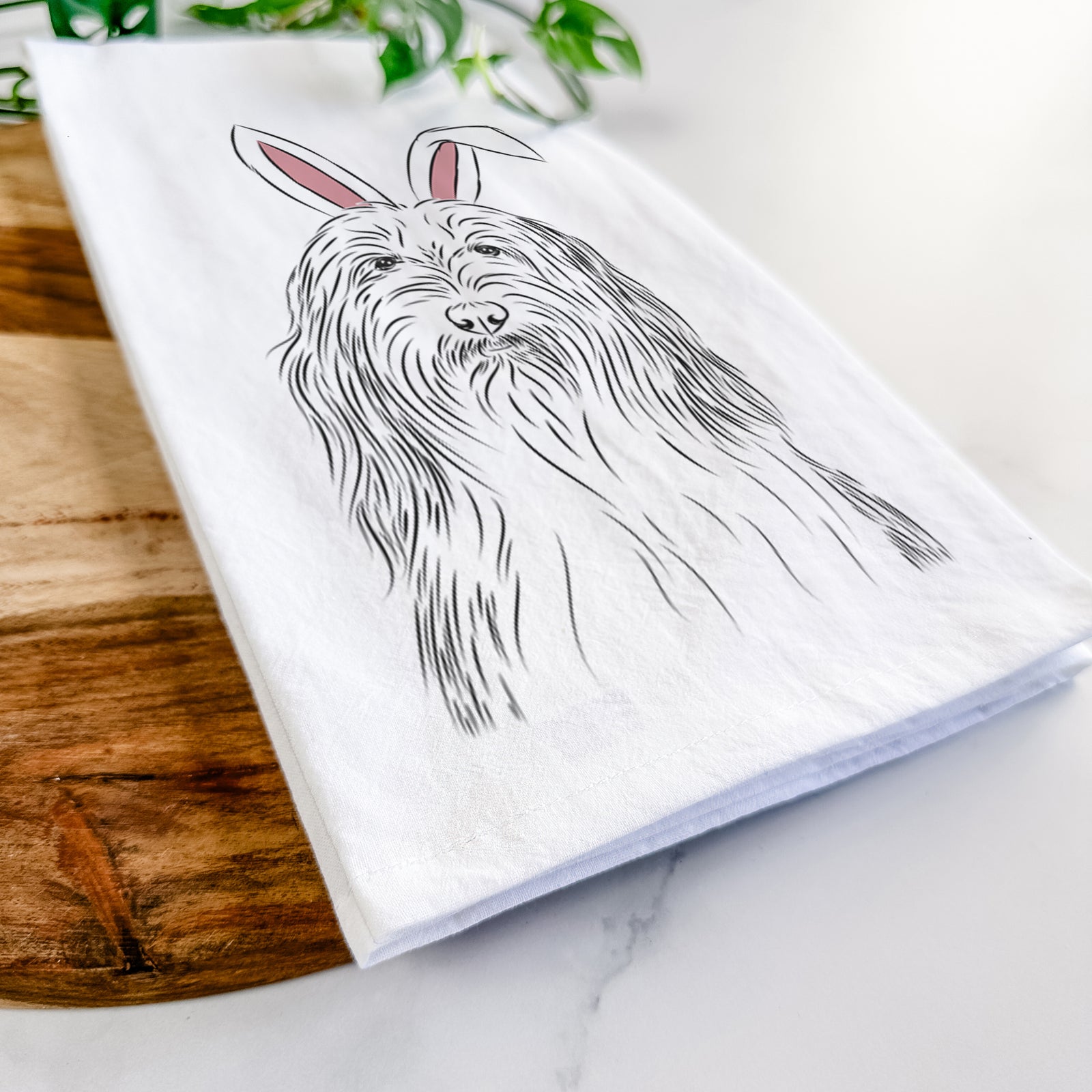 Hand-drawn sketch of Murray the Bearded Collie wearing Easter bunny ears on a tea towel