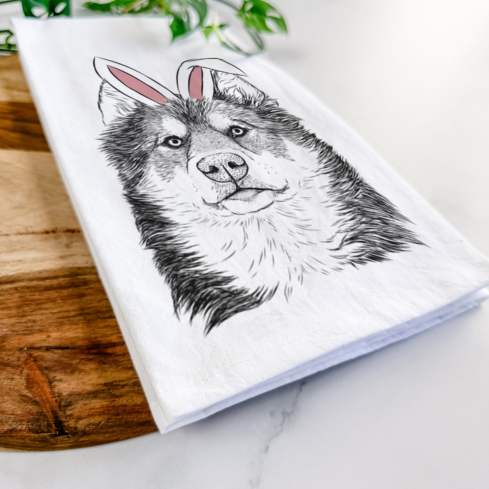 Hand-drawn sketch of Oskar the Canadian Eskimo Dog wearing Easter bunny ears on a tea towel