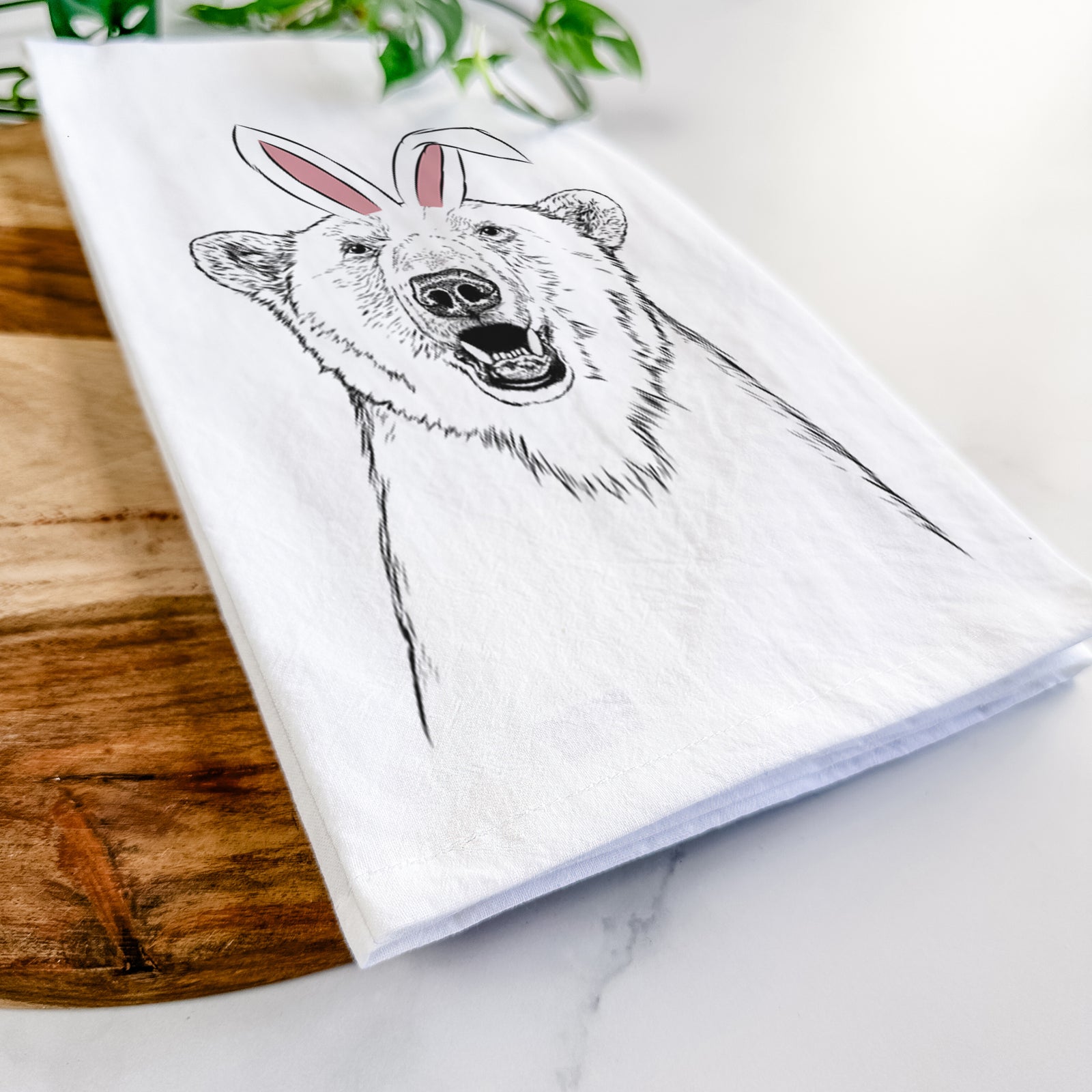 Hand-drawn sketch of Oslo the Polar Bear wearing Easter bunny ears on a tea towel