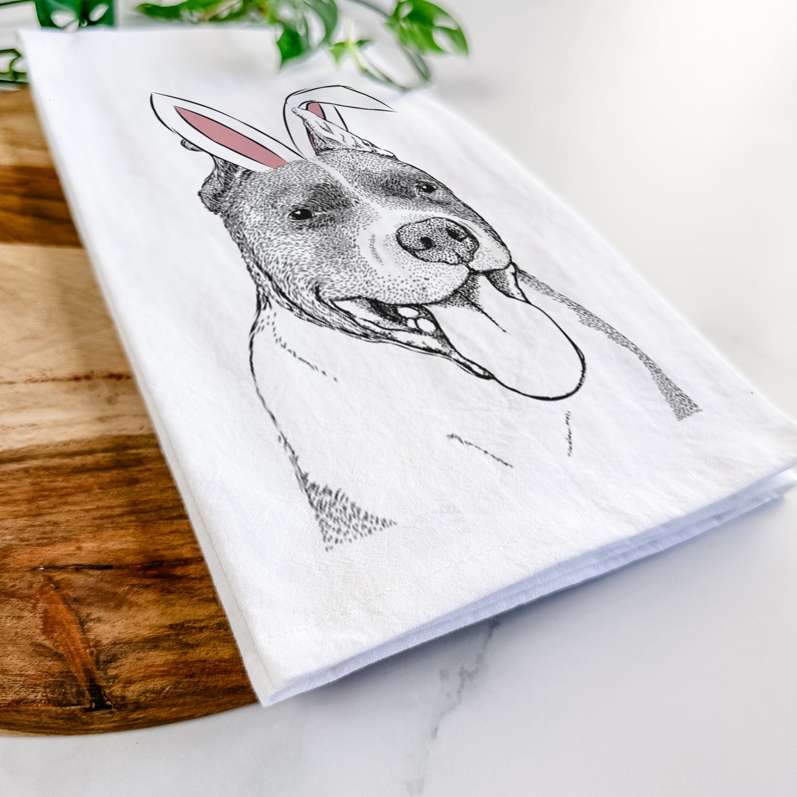 Hand-drawn sketch of Piggy the American Staffordshire Terrier wearing Easter bunny ears on a tea towel