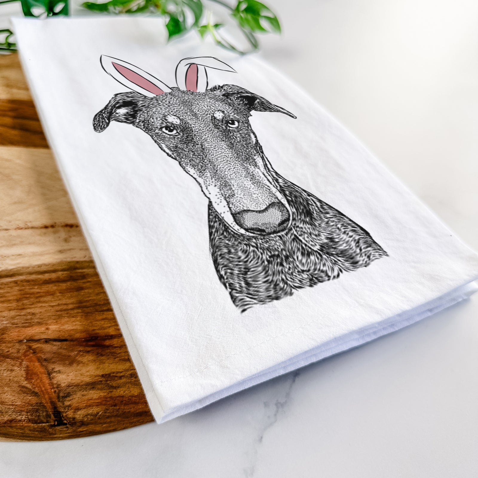 Hand-drawn sketch of Princess Fiona the Doberman Pinscher wearing Easter bunny ears on a tea towel