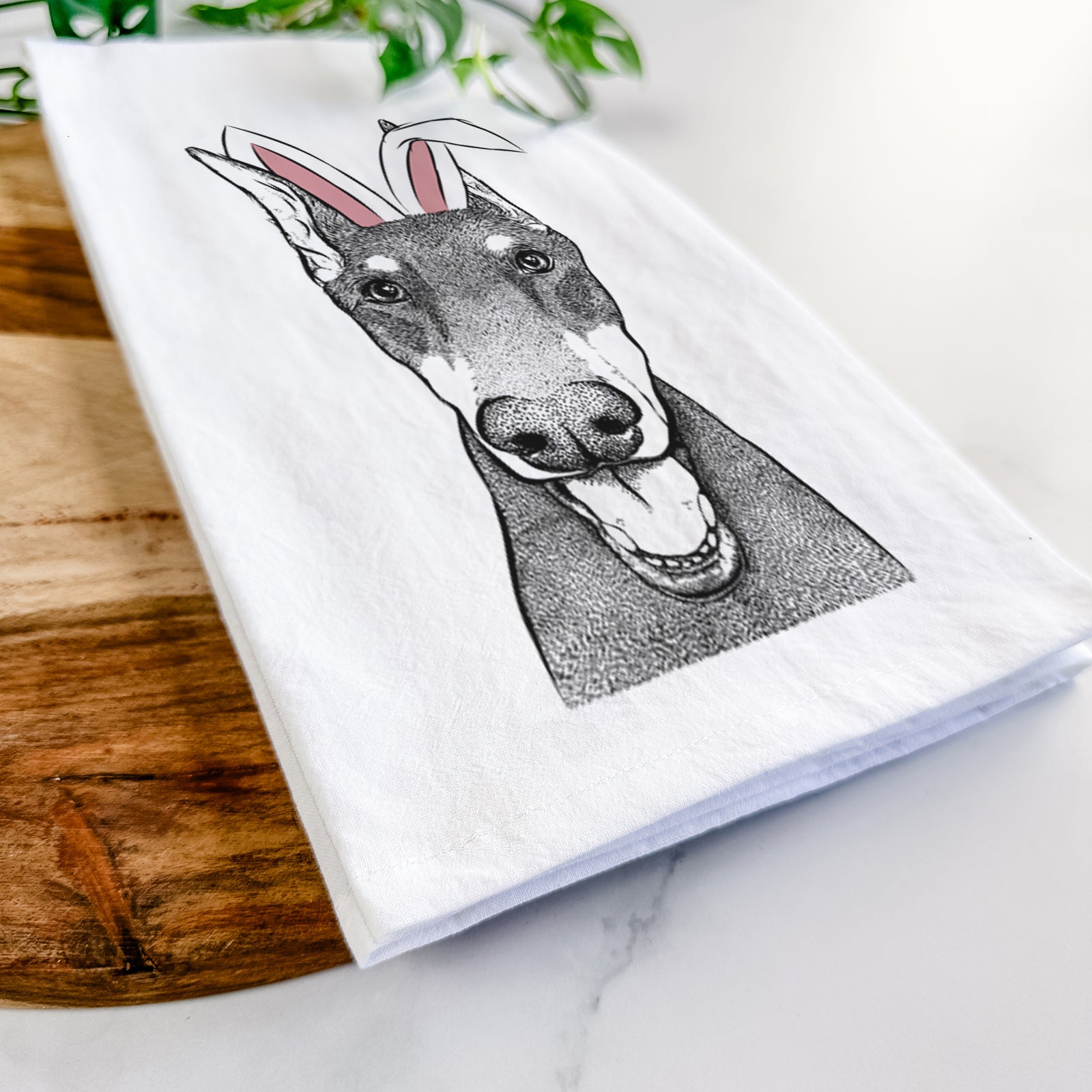 Hand-drawn sketch of Sir Duke the Doberman Pinscher wearing Easter bunny ears on a tea towel