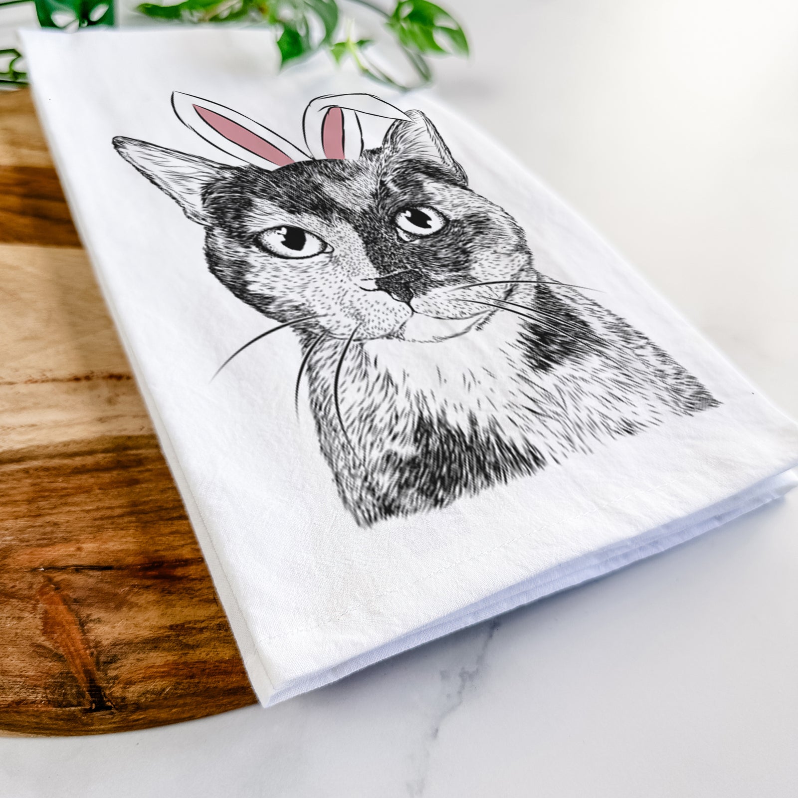 Hand-drawn sketch of Spooky Kitty the Tortoiseshell Cat wearing Easter bunny ears on a tea towel