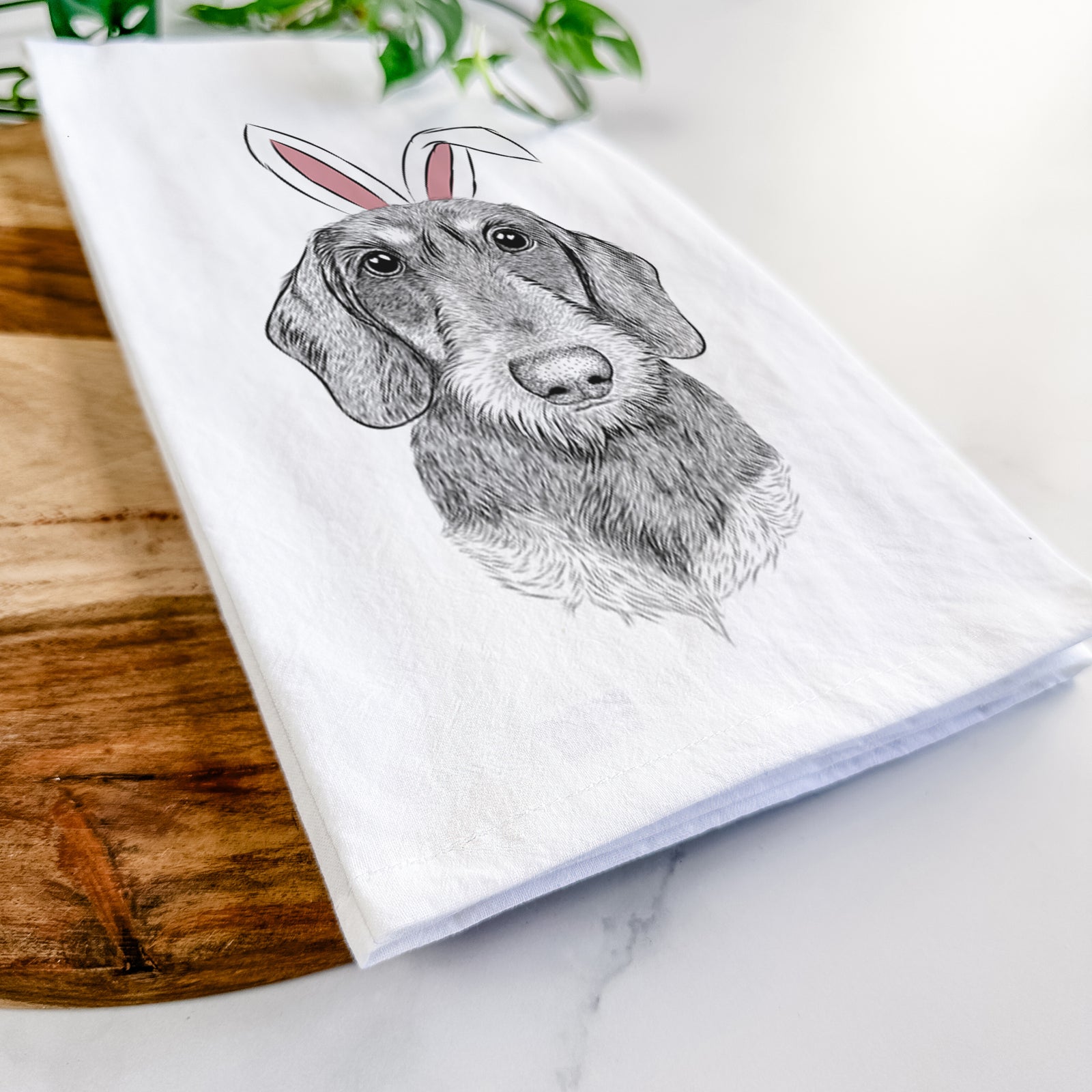 Hand-drawn sketch of Truman the Wirehaired Dachshund wearing Easter bunny ears on a tea towel