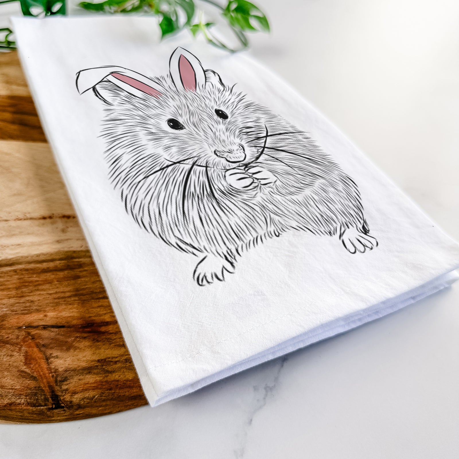 Hand-drawn sketch of Twitch the Hamster wearing Easter bunny ears on a tea towel