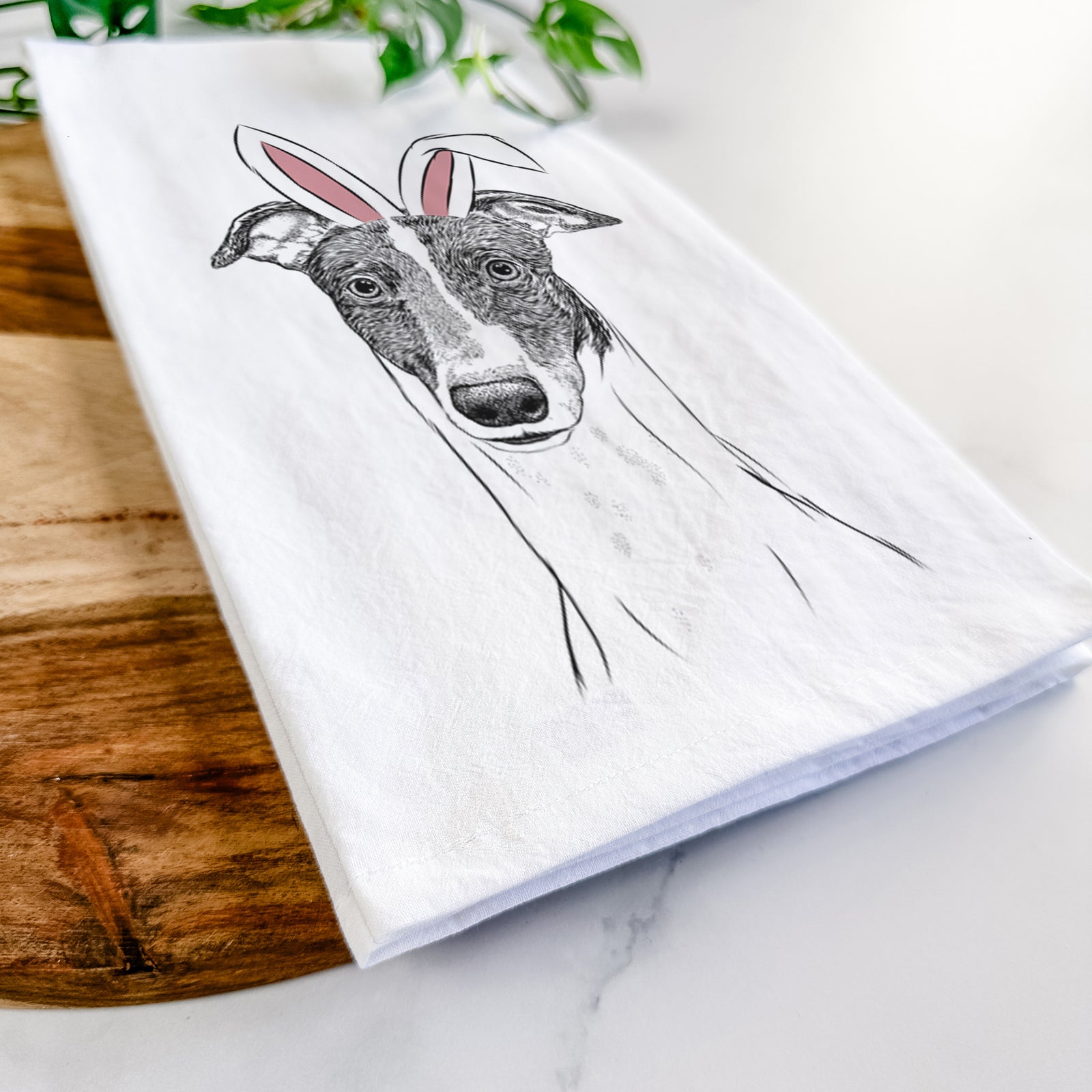 Hand-drawn sketch of Vyncent the Greyhound wearing Easter bunny ears on a tea towel