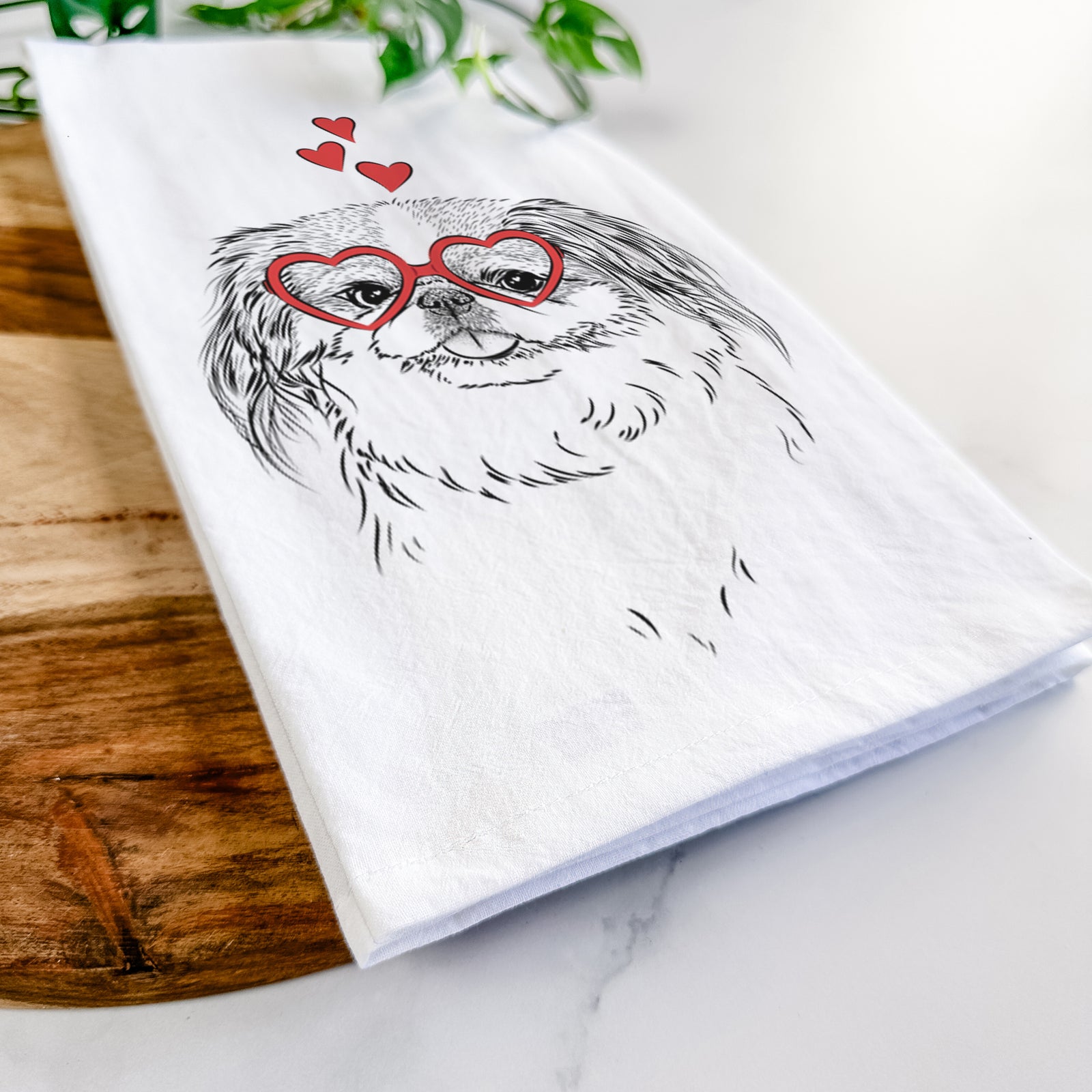 Hand-drawn sketch of Abra Bean the Pekingese wearing heart-shaped glasses on a tea towel