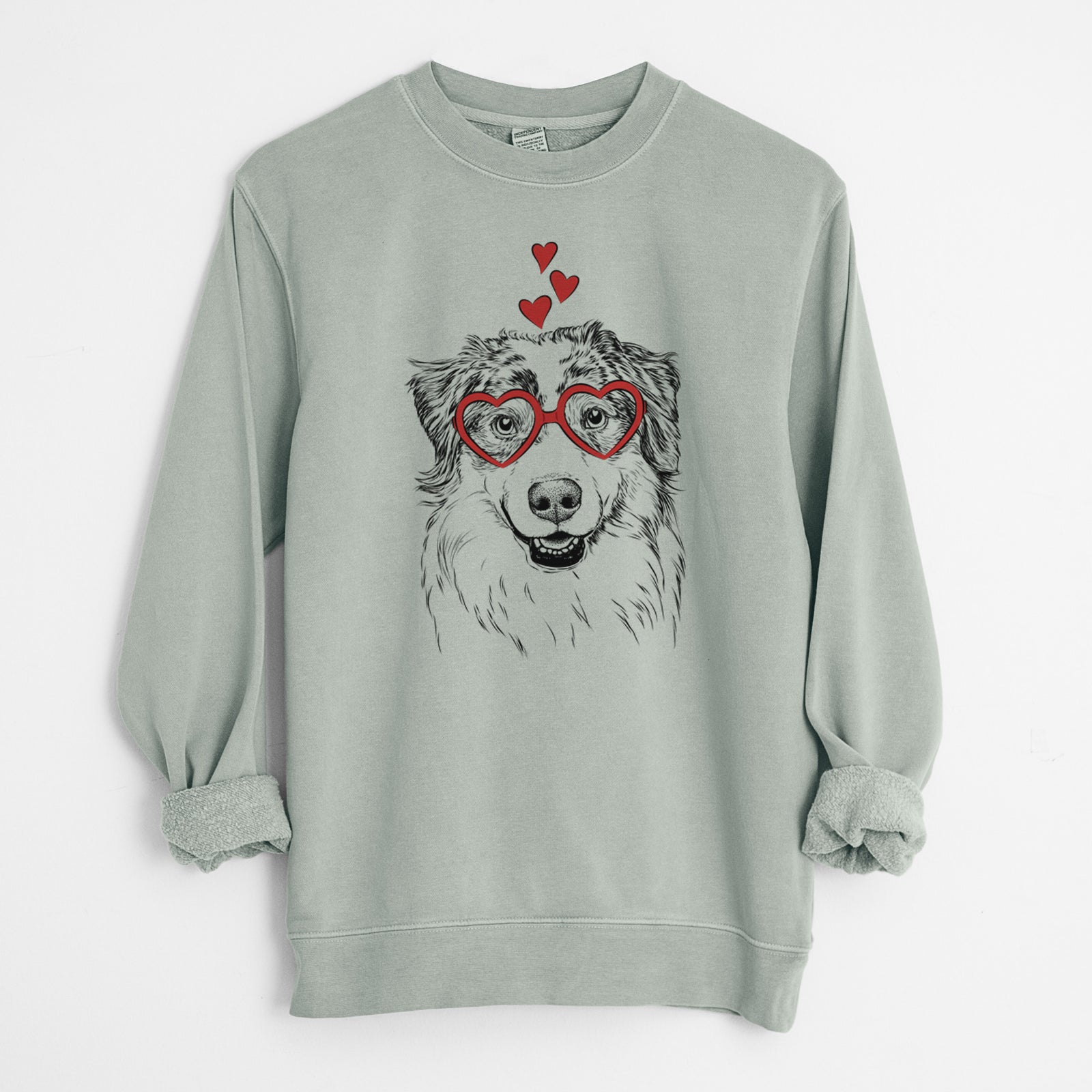 Hand-drawn sketch of Aonghus the Australian Shepherd wearing heart-shaped glasses on a Sage Unisex pigment dyed crew sweatshirt