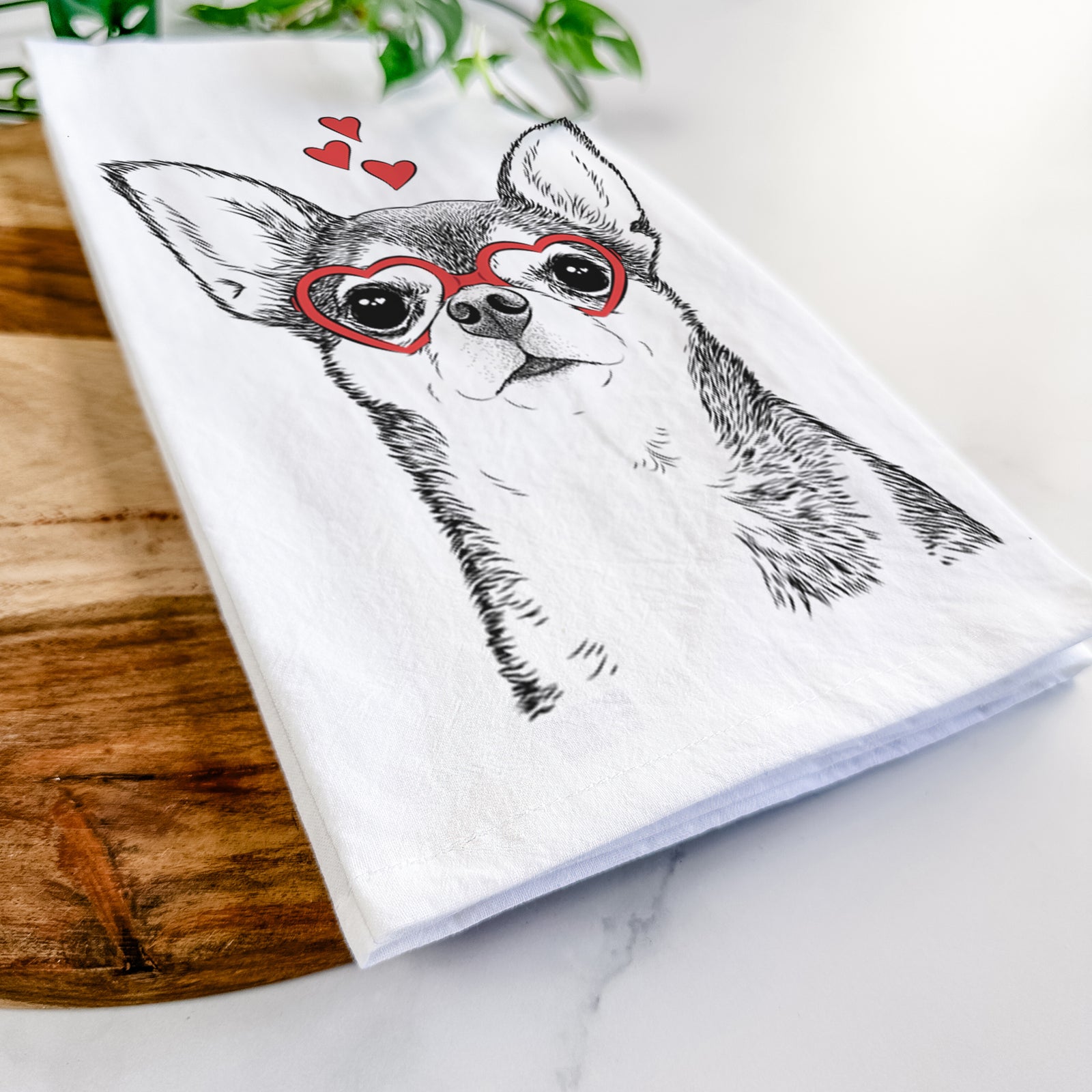 Hand-drawn sketch of Baby the Chihuahua wearing heart-shaped glasses on a tea towel