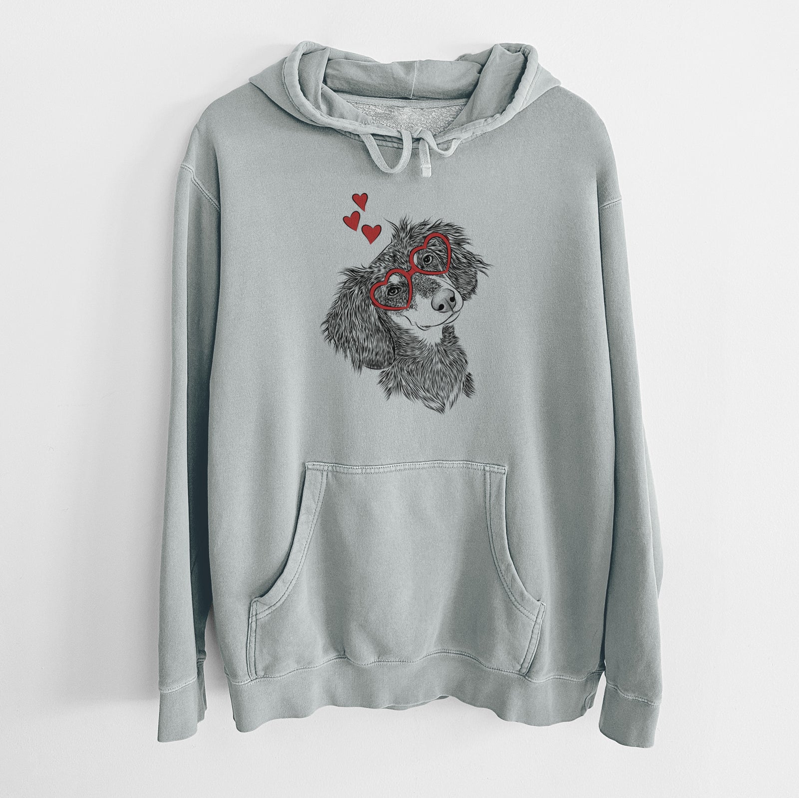 Hand-drawn sketch of Bailey the Long Haired Dachshund wearing heart-shaped glasses on a Sage Unisex pigment dyed hoodie