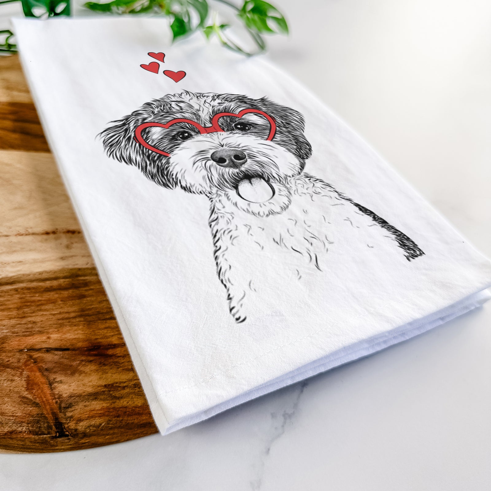 Hand-drawn sketch of Bella the Cockapoo wearing heart-shaped glasses on a tea towel