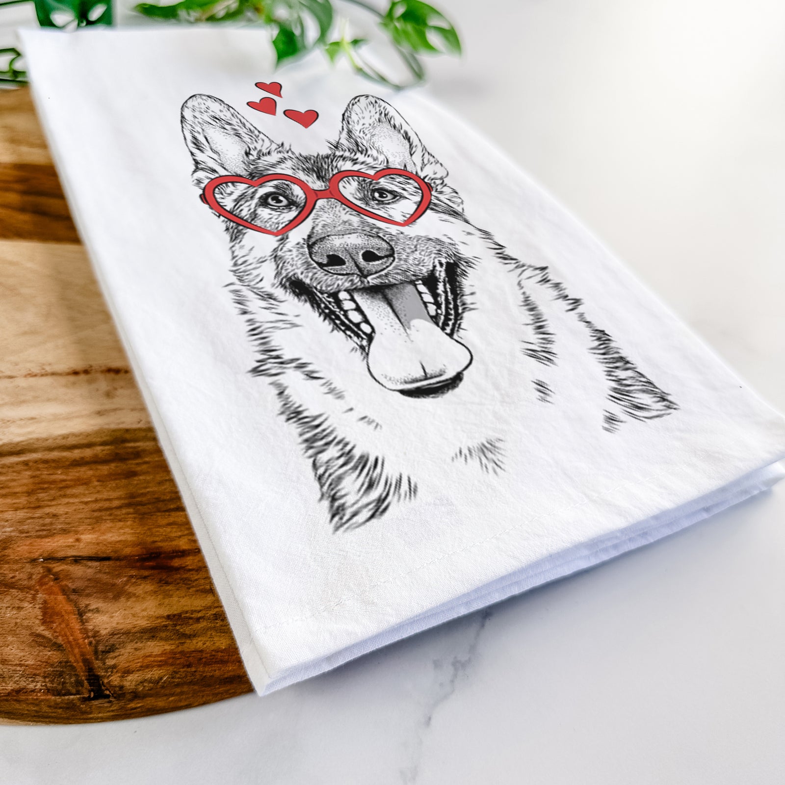 Hand-drawn sketch of Benson the German Shepherd wearing heart-shaped glasses on a tea towel