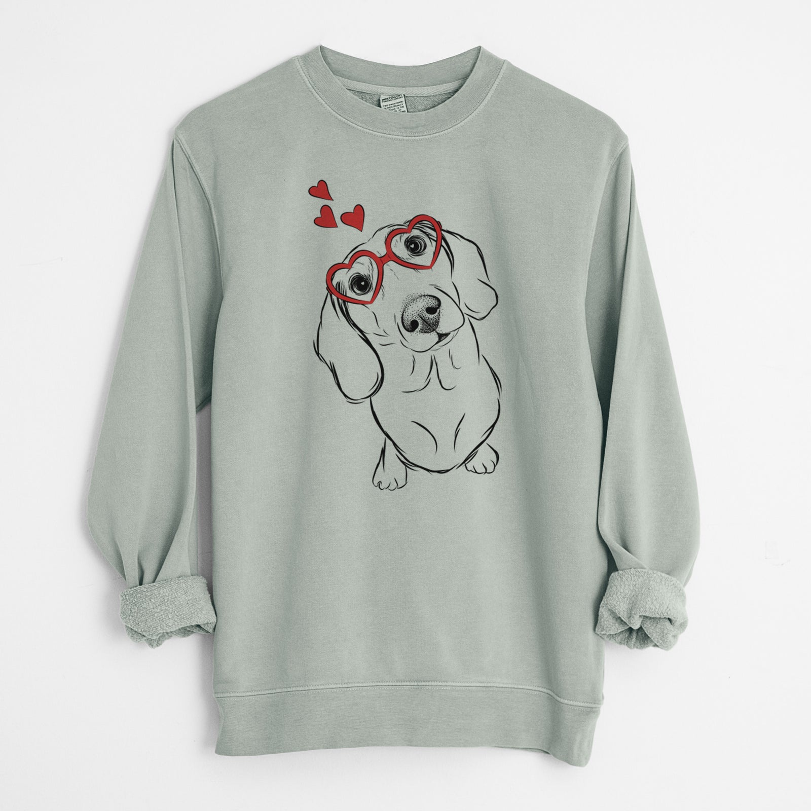 Hand-drawn sketch of Bill the Dachshund wearing heart-shaped glasses on a Sage Unisex pigment dyed crew sweatshirt