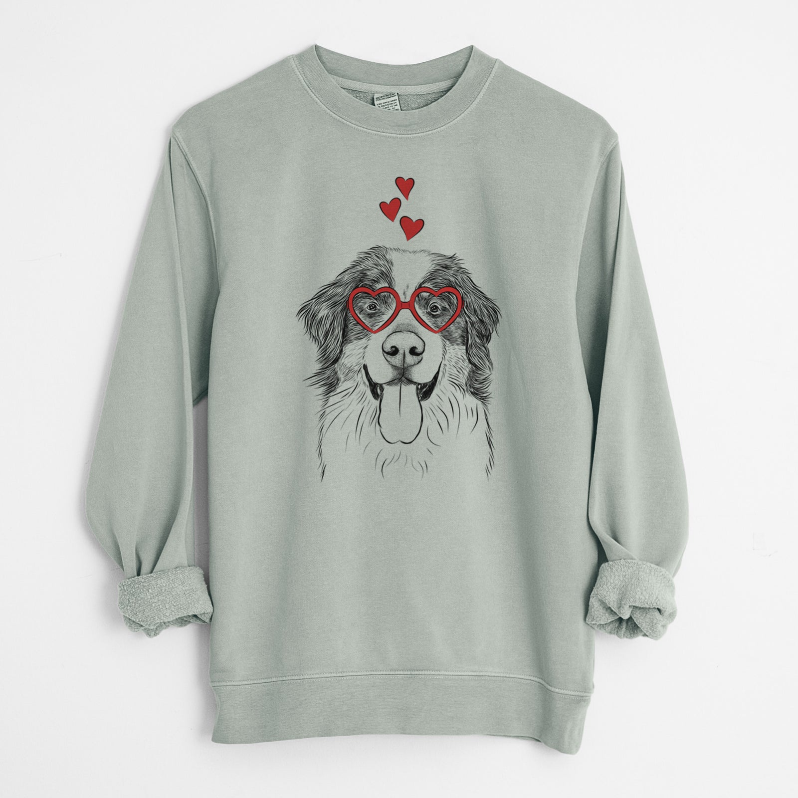 Hand-drawn sketch of Blaze the Bernese Mountain Dog wearing heart-shaped glasses on a Sage Unisex pigment dyed crew sweatshirt