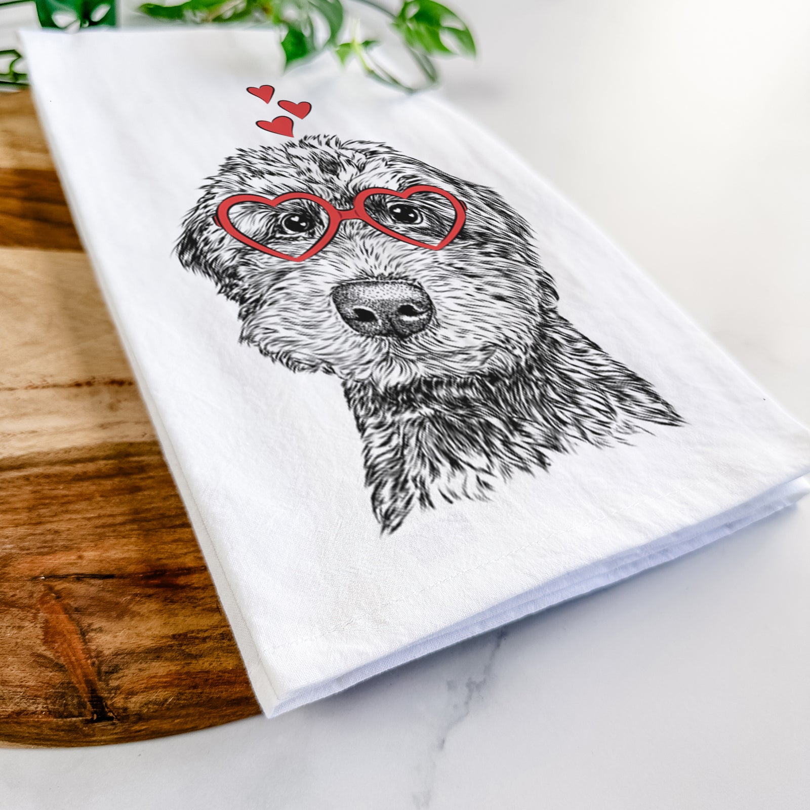 Hand-drawn sketch of Bowser the Whoodle wearing heart-shaped glasses on a tea towel