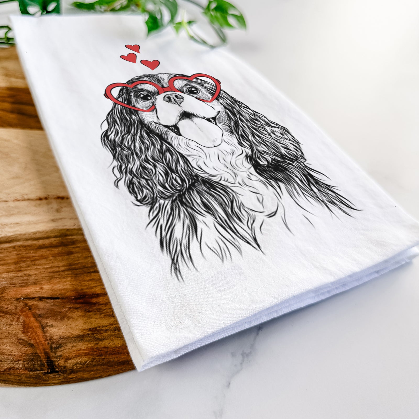 Hand-drawn sketch of Brandy the Cavalier King Charles Spaniel wearing heart-shaped glasses on a tea towel