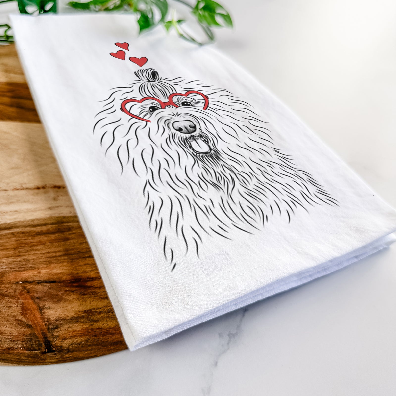 Hand-drawn sketch of Brody the Old English Sheepdog wearing heart-shaped glasses on a tea towel