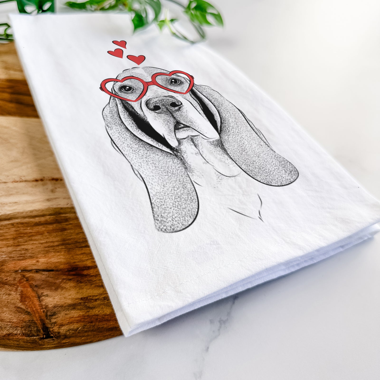 Hand-drawn sketch of Buckley the Basset Hound wearing heart-shaped glasses on a tea towel