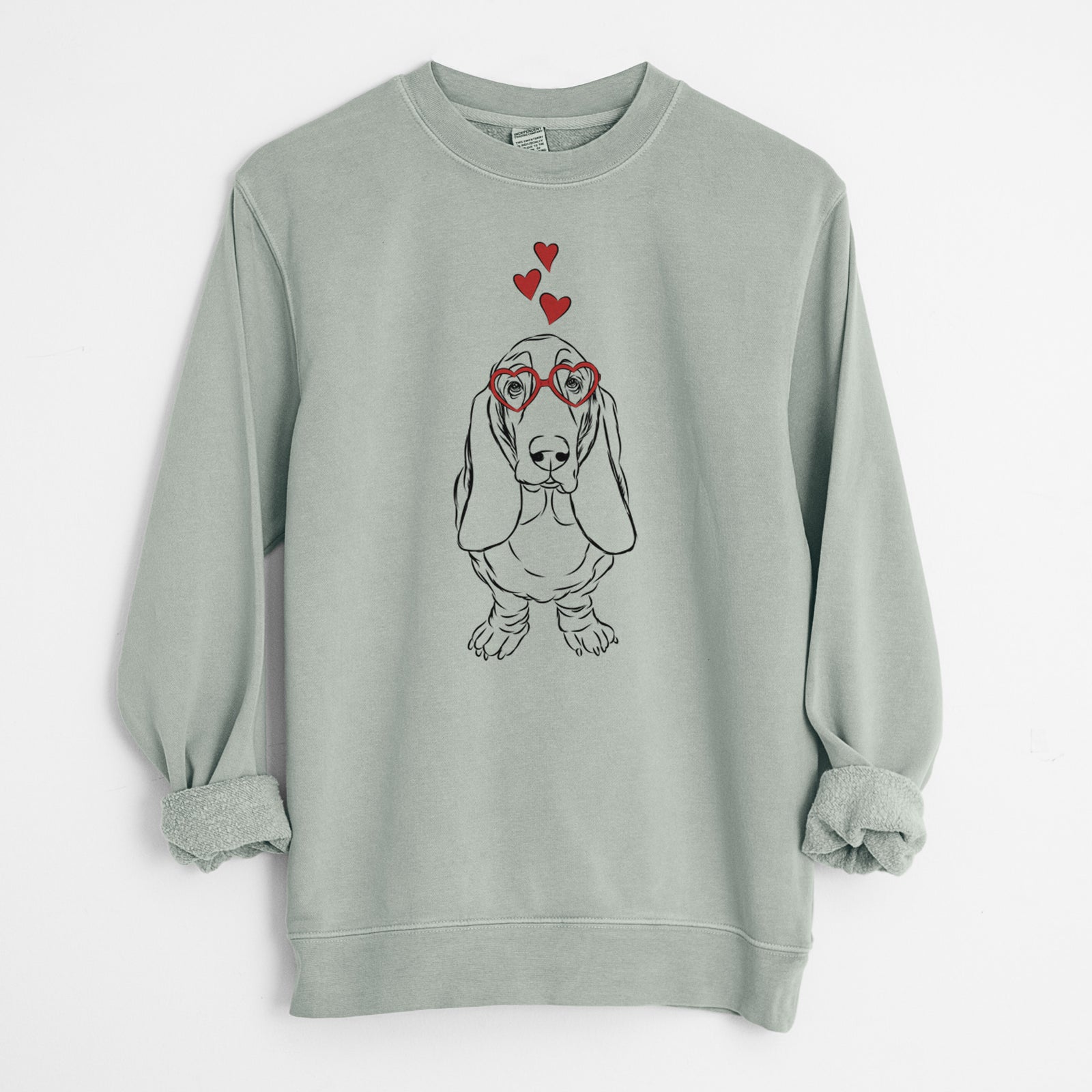 Hand-drawn sketch of Charlie the Basset Hound wearing heart-shaped glasses on a Sage Unisex pigment dyed crew sweatshirt