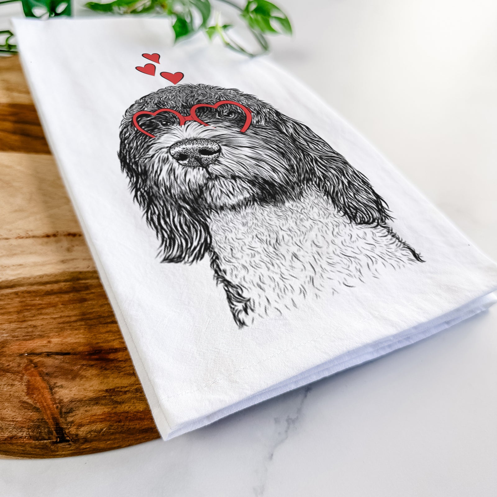 Hand-drawn sketch of Chris the Portuguese Water Dog wearing heart-shaped glasses on a tea towel