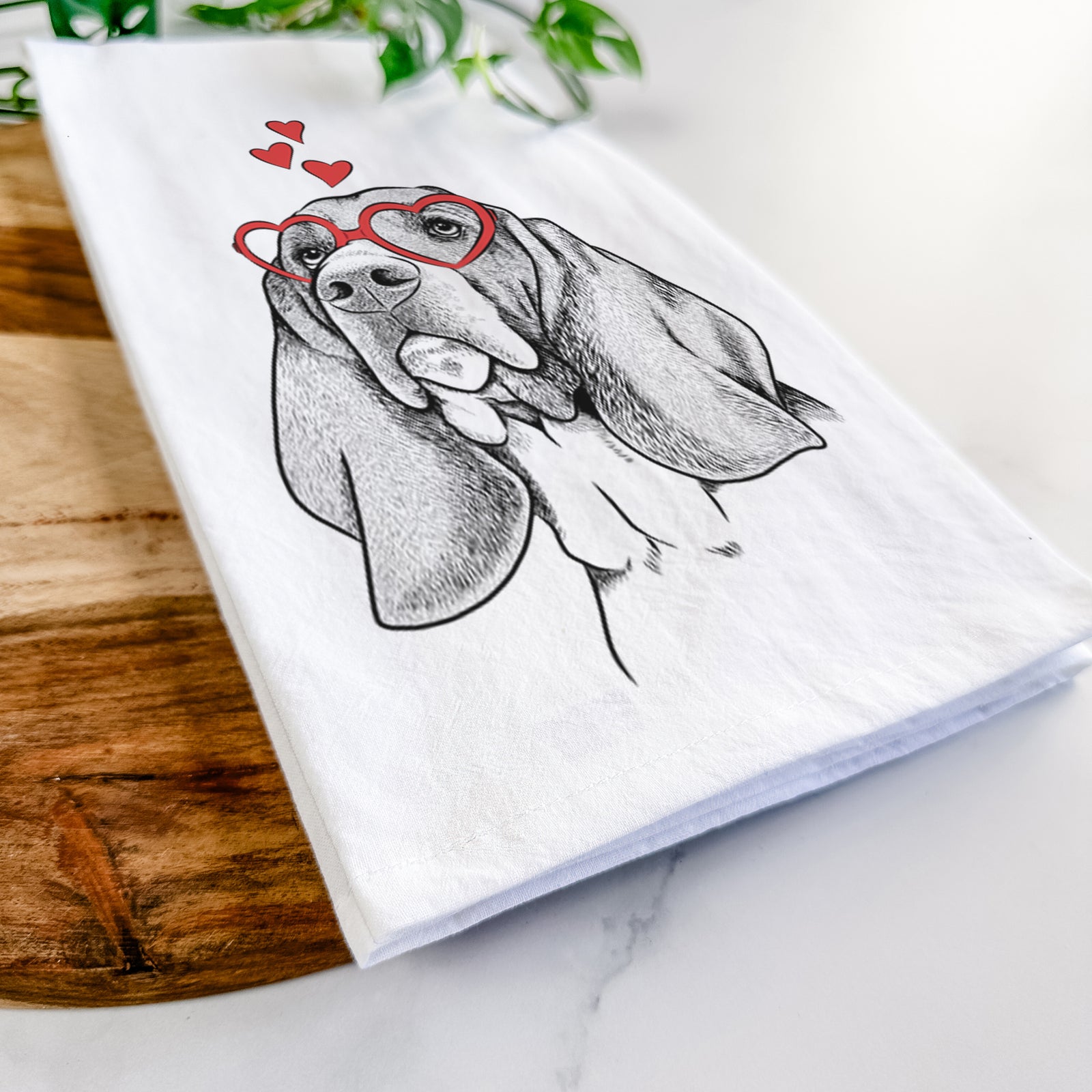 Hand-drawn sketch of Cooper the Basset Hound wearing heart-shaped glasses on a tea towel