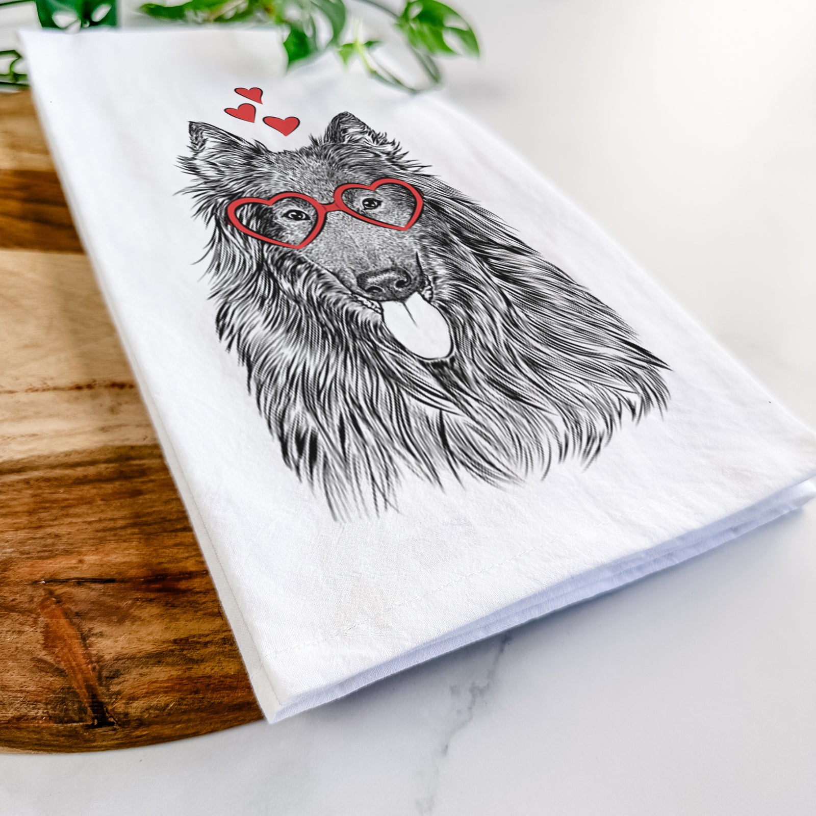 Hand-drawn sketch of Daan the Belgian Shepherd wearing heart-shaped glasses on a tea towel