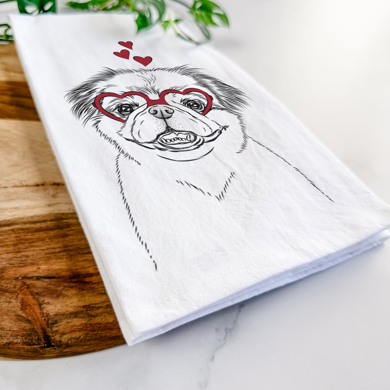 Hand-drawn sketch of Danny the Pekingese wearing heart-shaped glasses on a tea towel