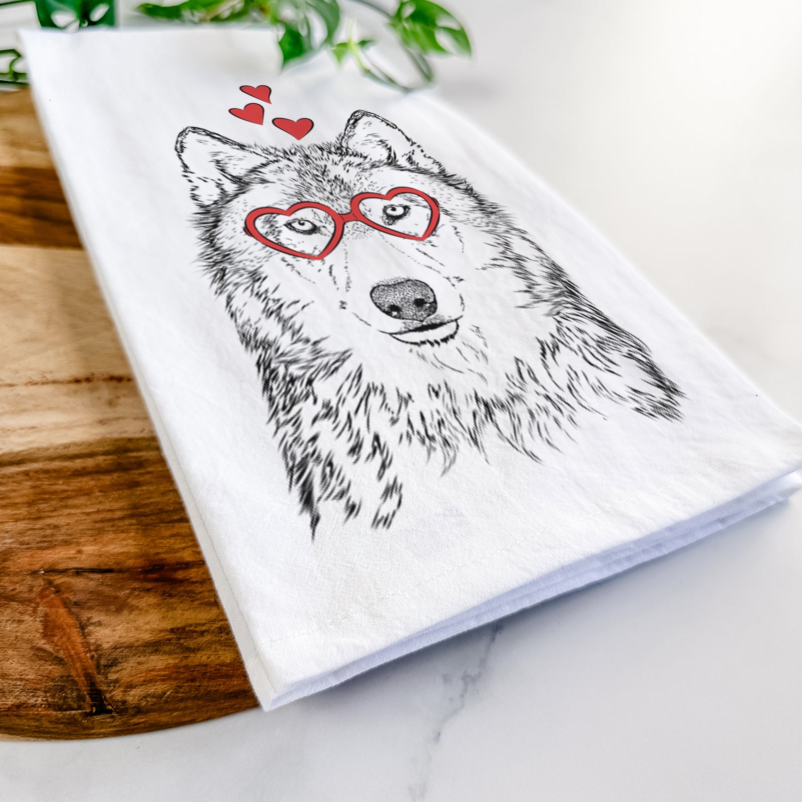Hand-drawn sketch of Django the Grey Wolf wearing heart-shaped glasses on a tea towel