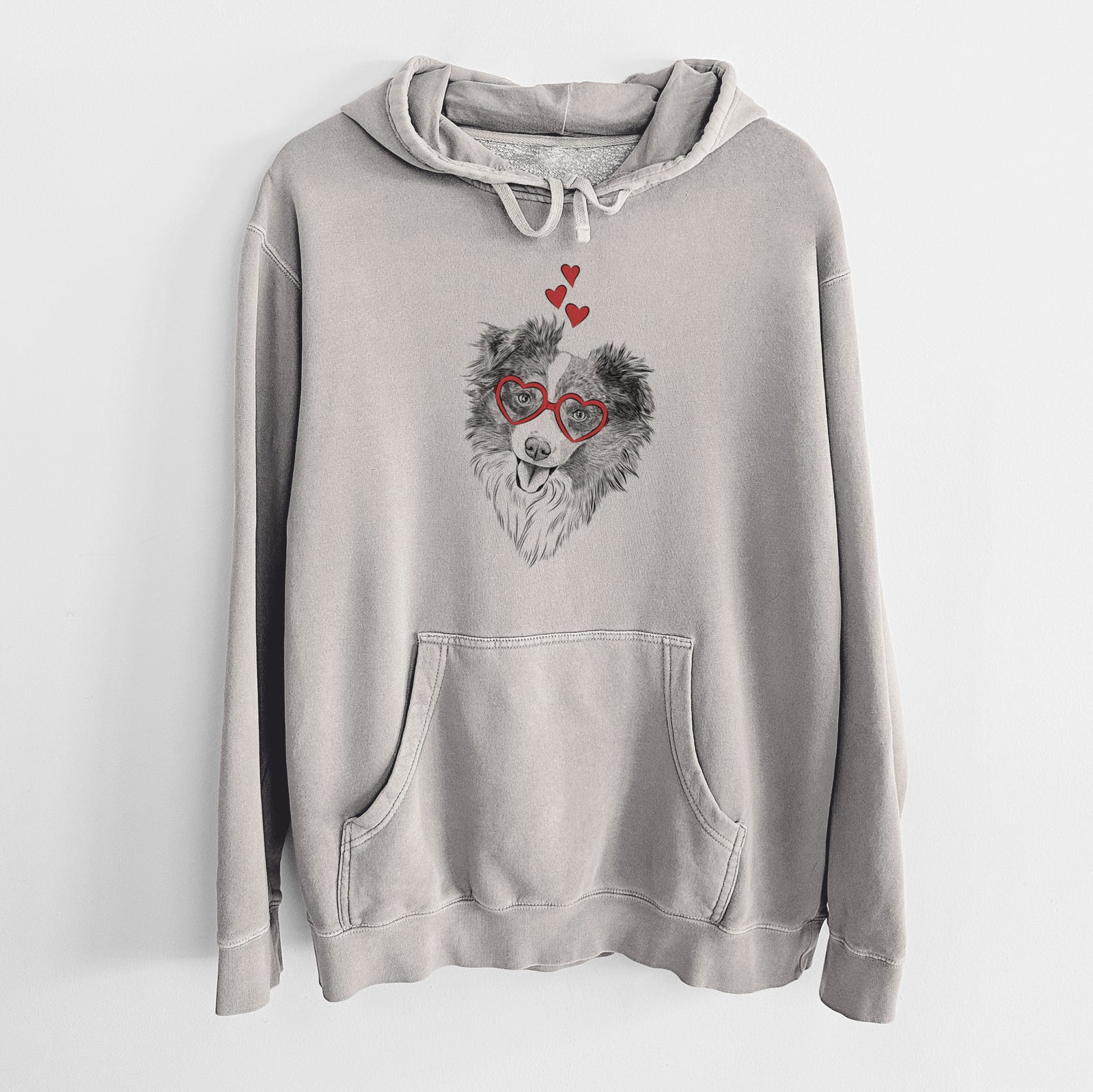 Hand-drawn sketch of Doc the Mini Aussie wearing heart-shaped glasses on a Cement Unisex pigment dyed hoodie