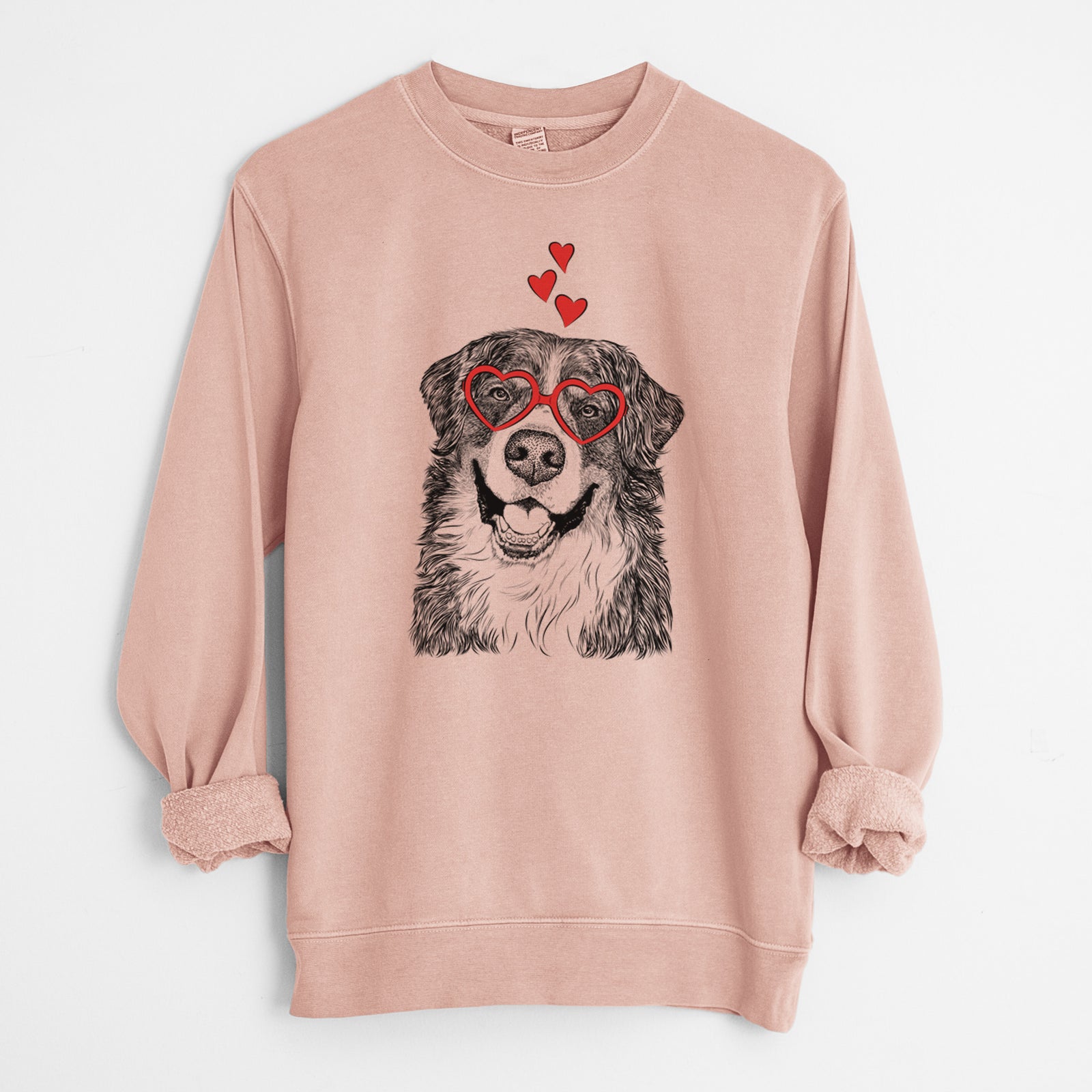 Hand-drawn sketch of Eiger the Bernese Mountain Dog wearing heart-shaped glasses on a Dusty Pink Unisex pigment dyed crew sweatshirt