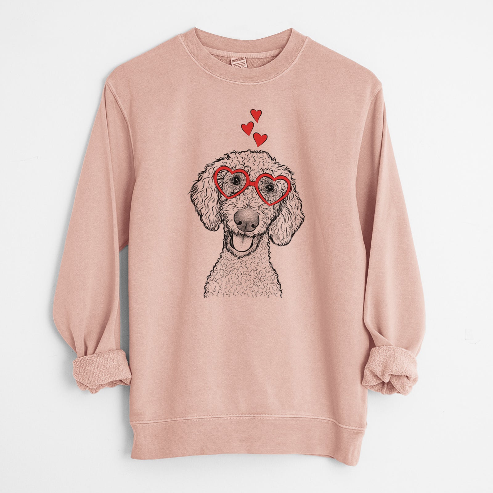 Hand-drawn sketch of Fenway the Goldendoodle wearing heart-shaped glasses on a Dusty Pink Unisex pigment dyed crew sweatshirt